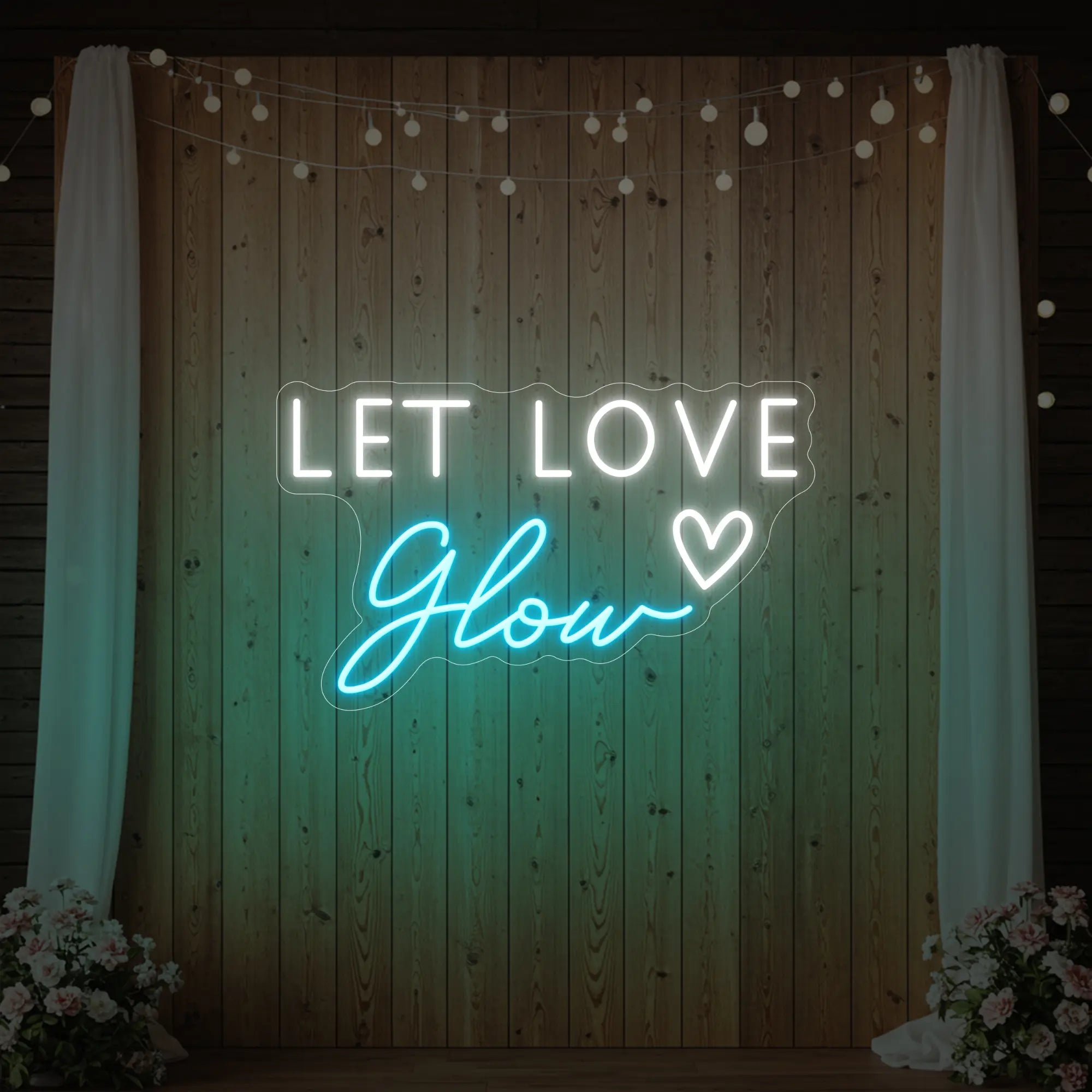 Photo of the 'Let Love Glow' neon sign glowing in ice blue against a styled interior wall.