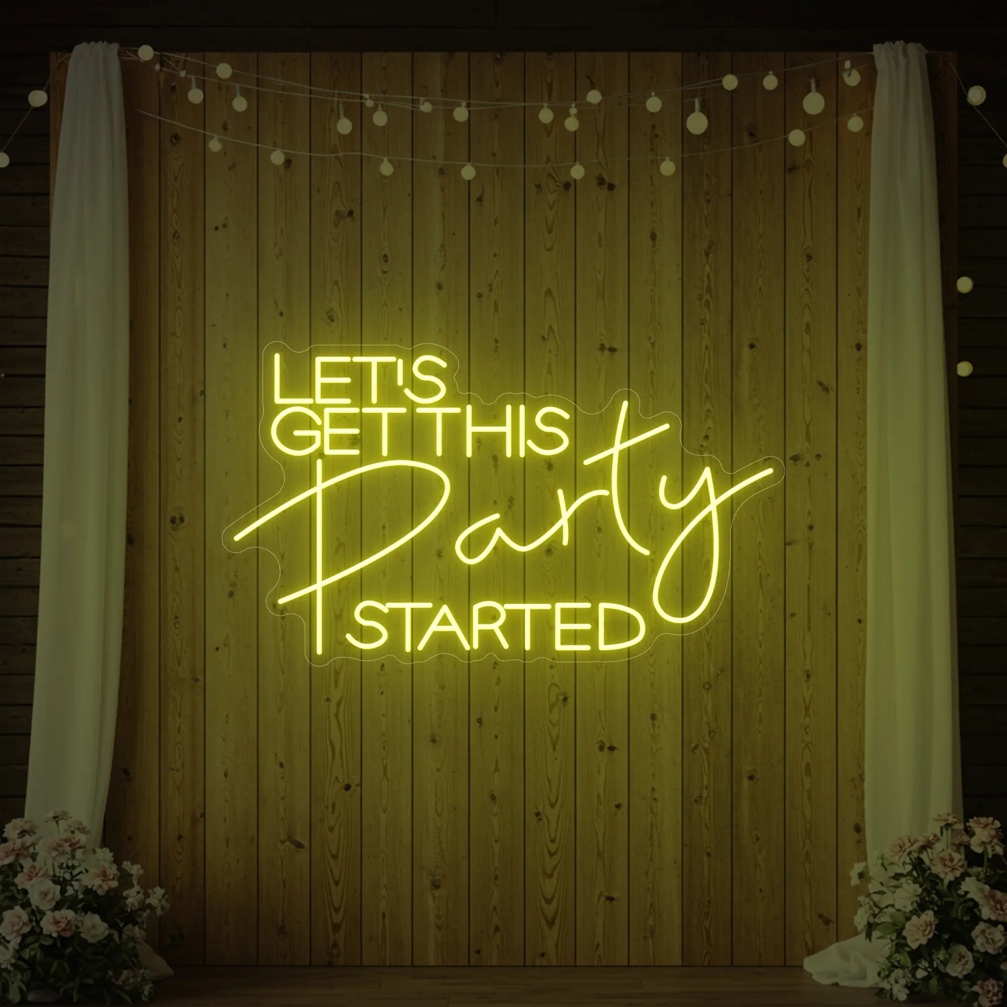 Photo of the 'Let’s Get This Party Started' neon sign glowing in lemon yellow against a styled interior wall.