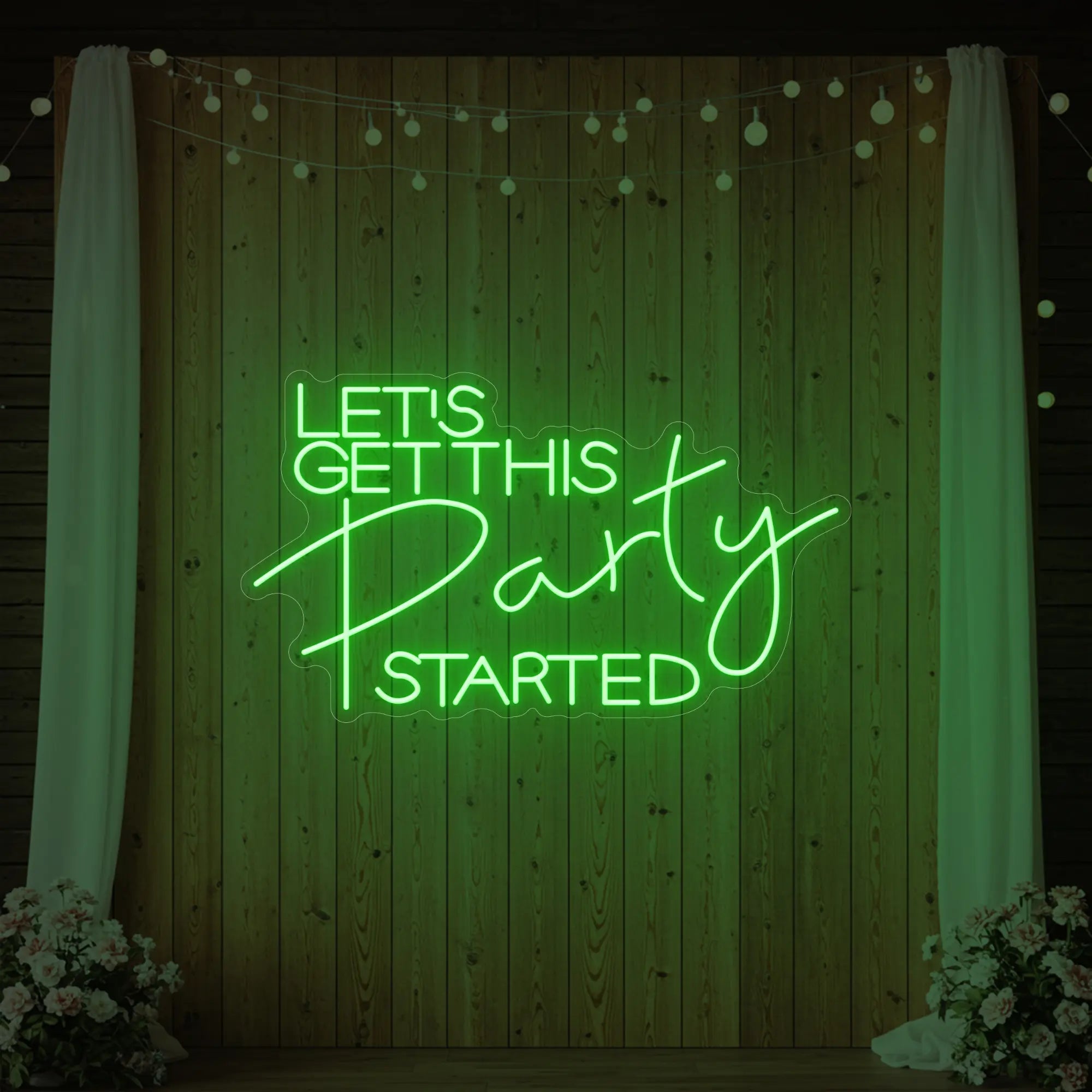 Photo of the 'Let’s Get This Party Started' neon sign glowing in green against a styled interior wall.