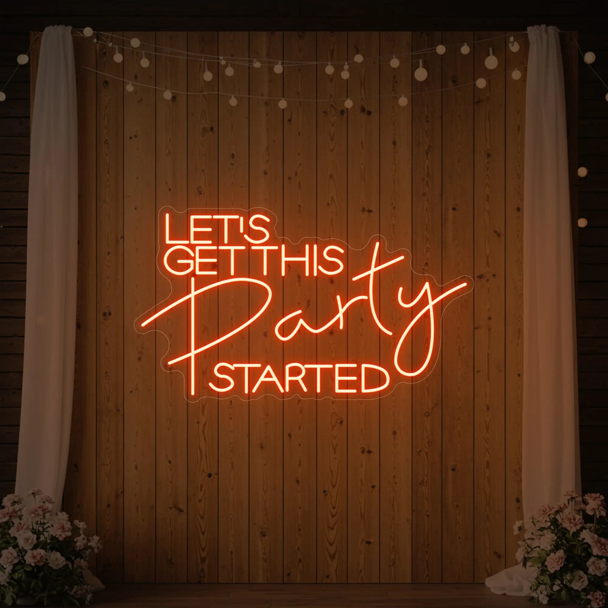 Photo of the 'Let’s Get This Party Started' neon sign glowing in golden yellow against a styled interior wall.