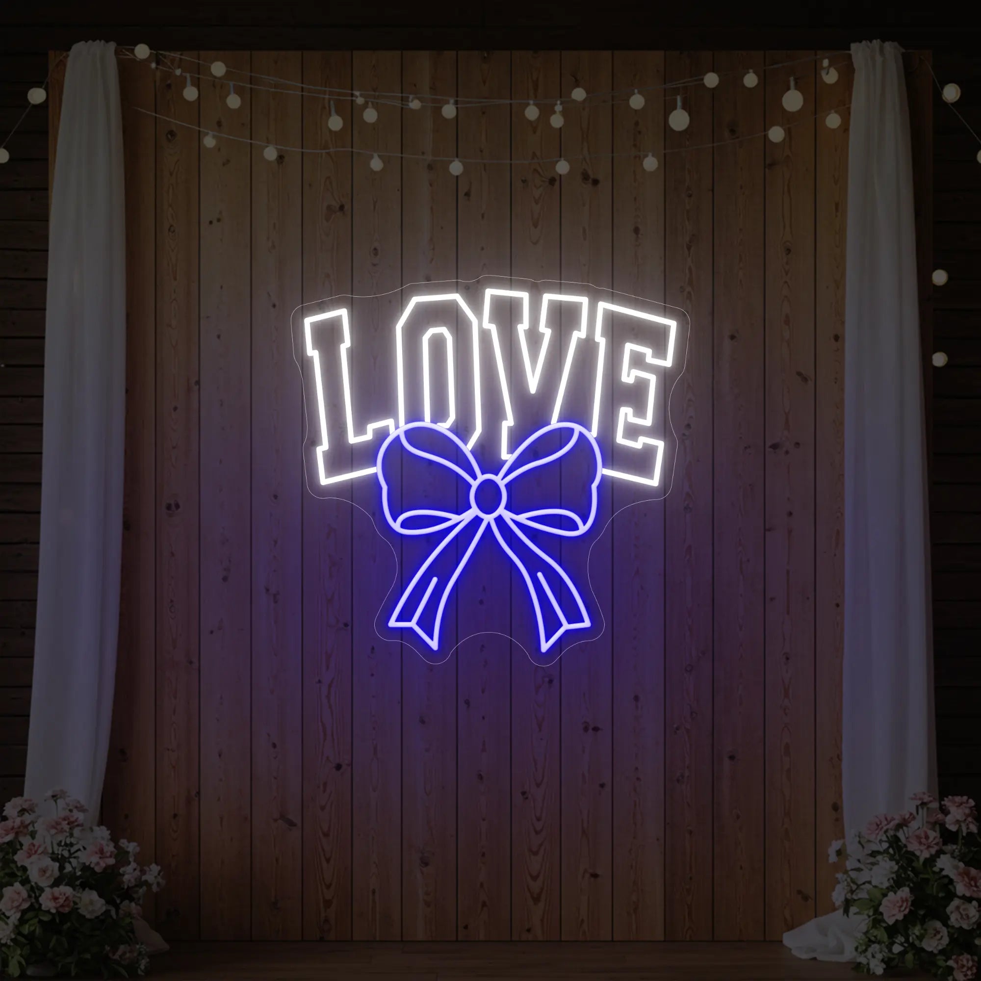 Photo of the 'Love and Ribbon' neon sign glowing in deep blue against a styled interior wall.