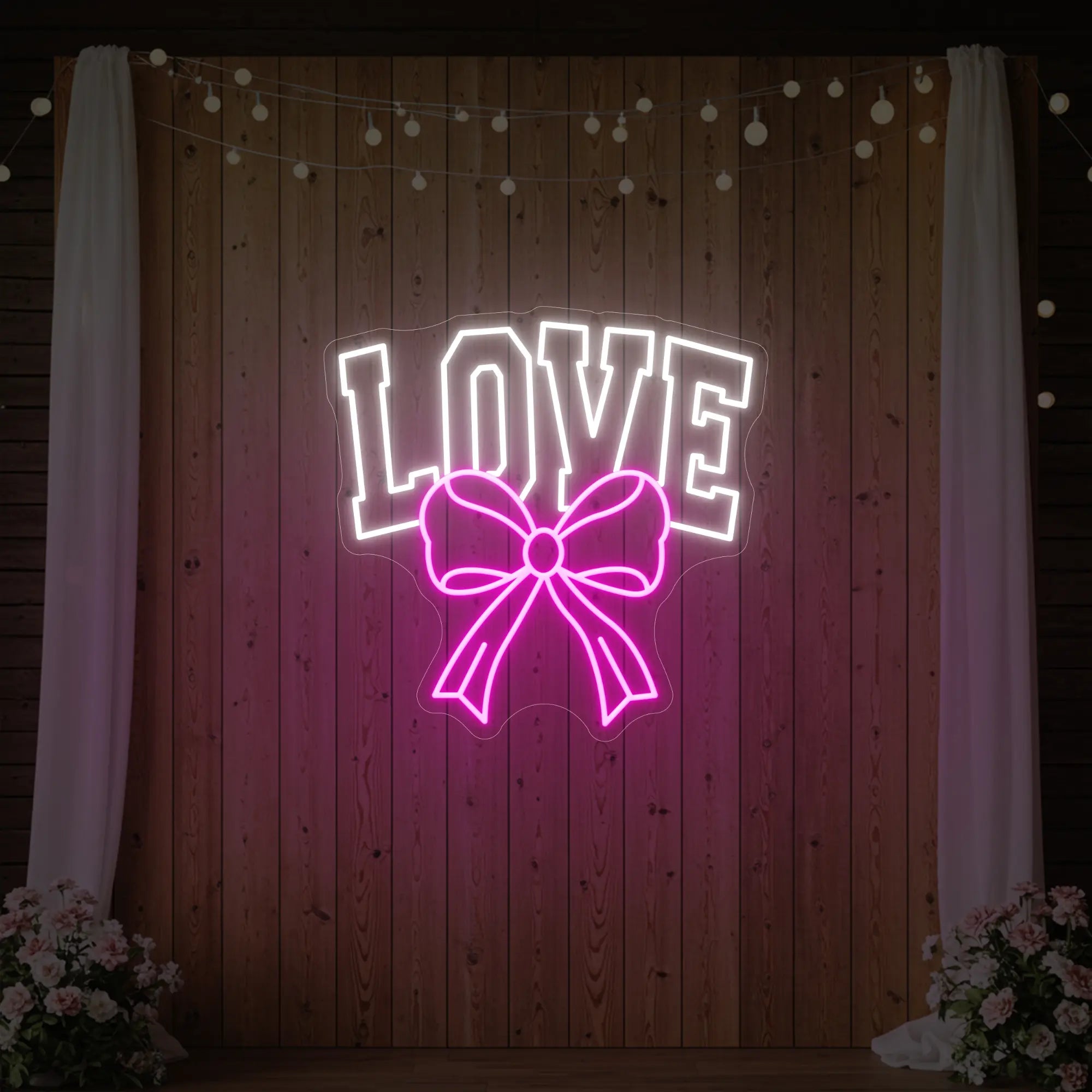 Photo of the 'Love and Ribbon' neon sign glowing in light pink against a styled interior wall.