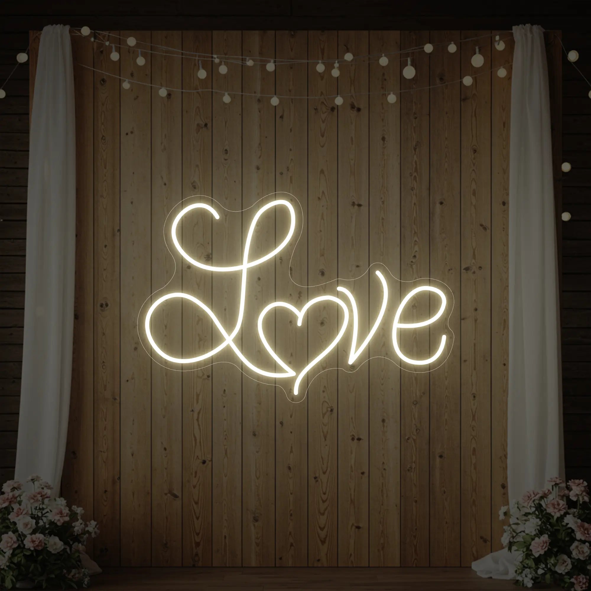 Photo of the 'Love Heart' neon sign glowing in warm white against a styled background.