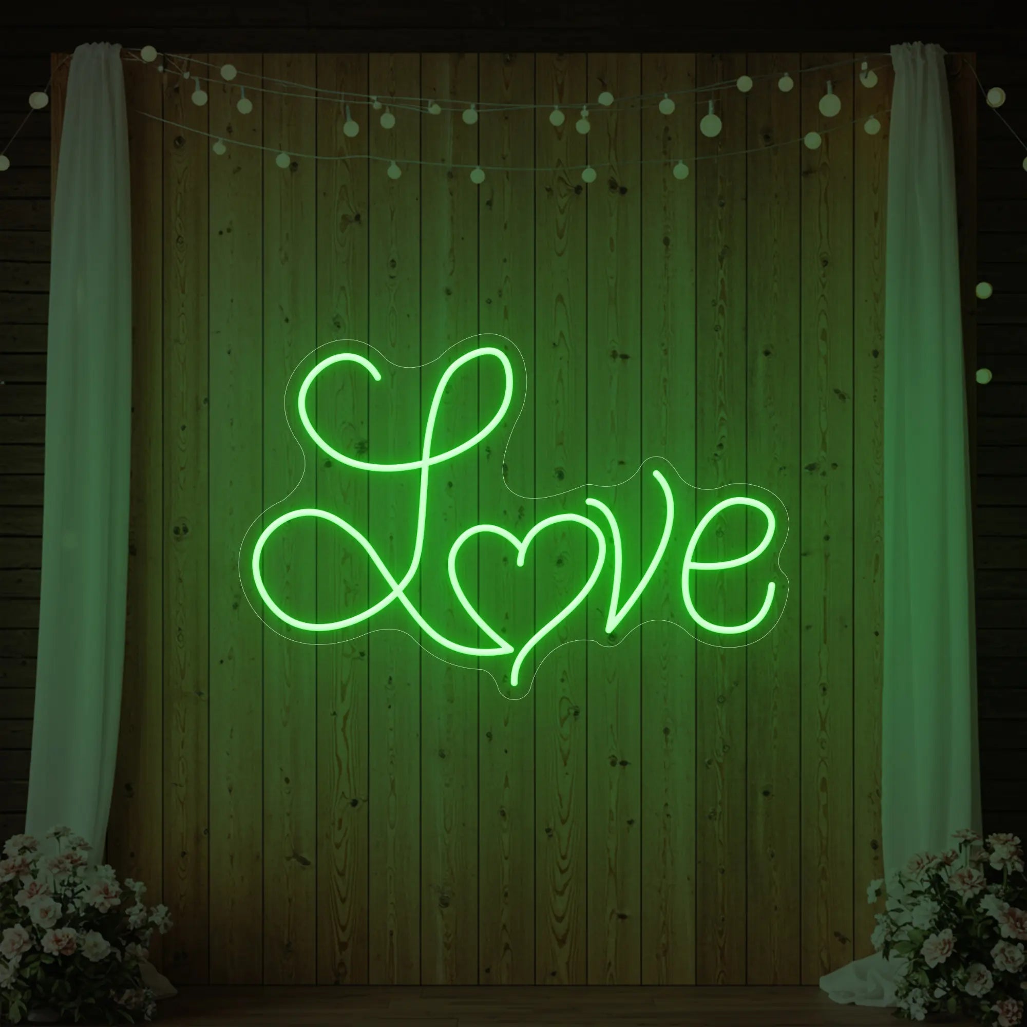 Photo of the 'Love Heart' neon sign glowing in green against a styled interior wall.
