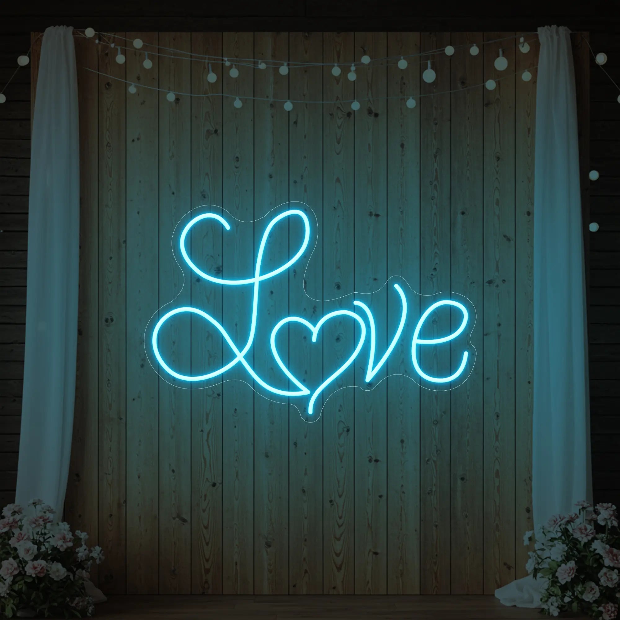 Photo of the 'Love Heart' neon sign glowing in ice blue against a styled interior wall.