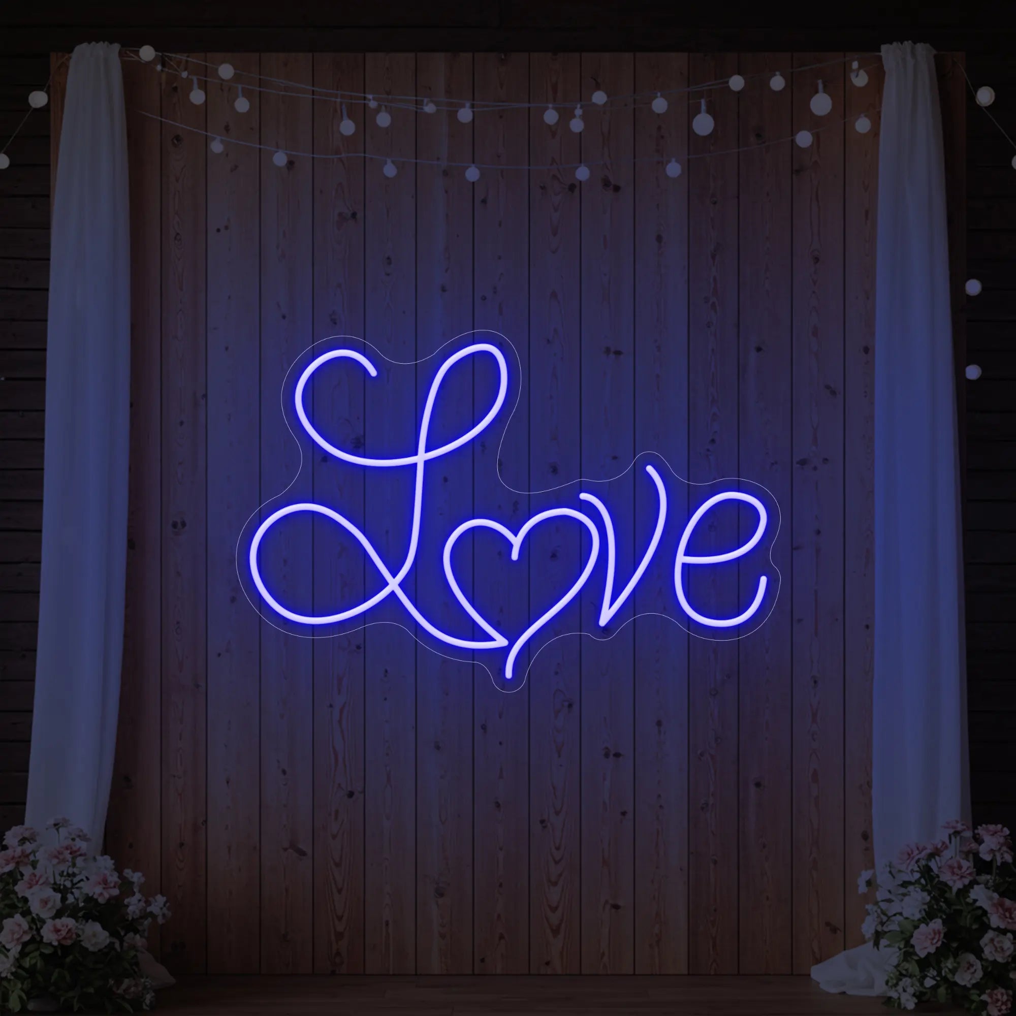 Photo of the 'Love Heart' neon sign glowing in deep blue against a styled interior wall.