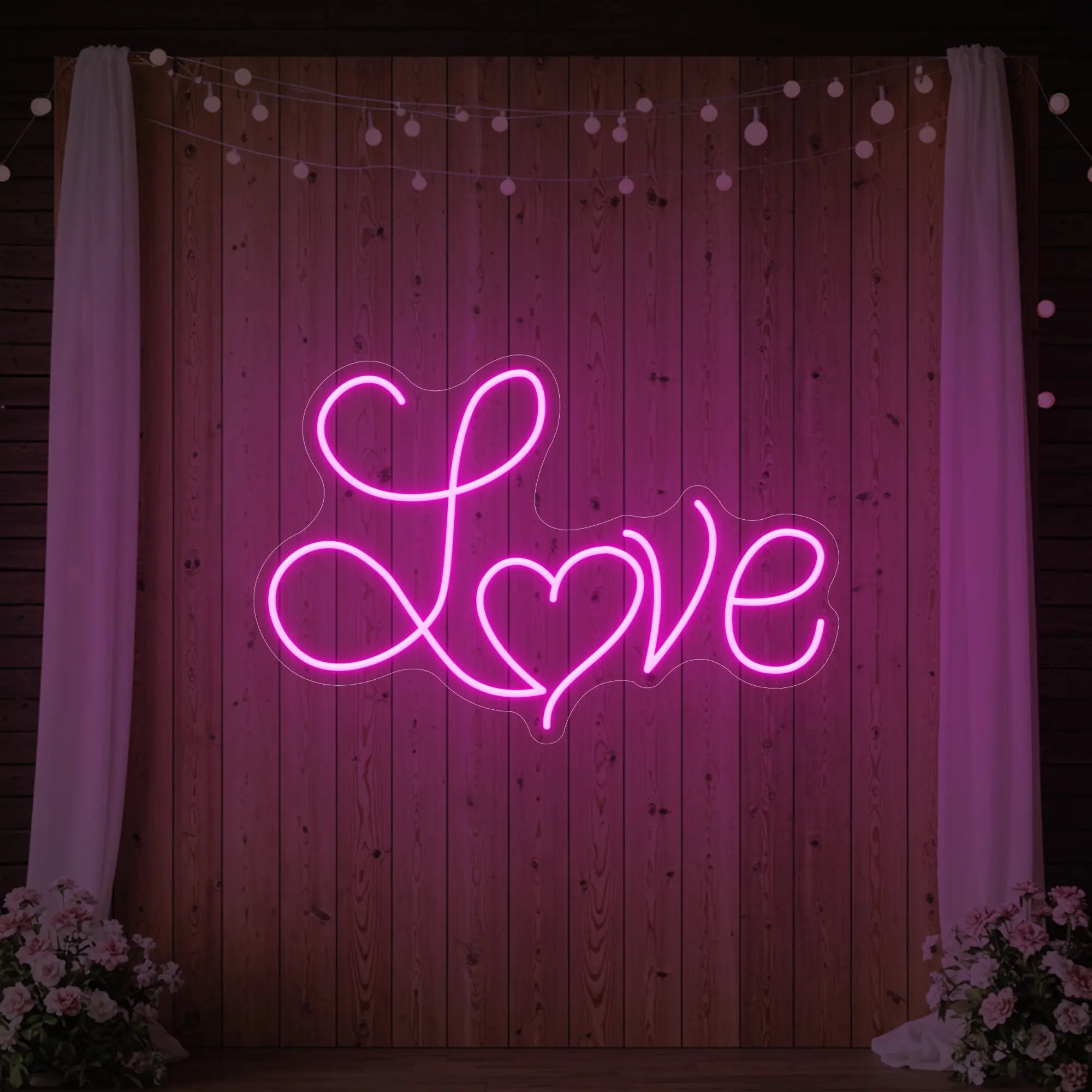 Photo of the 'Love Heart' neon sign glowing in light pink against a styled interior wall.