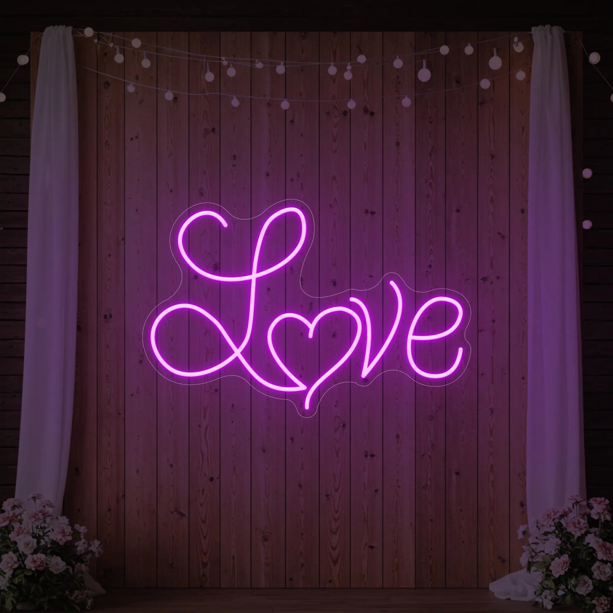 Photo of the 'Love Heart' neon sign glowing in deep pink against a styled interior wall.