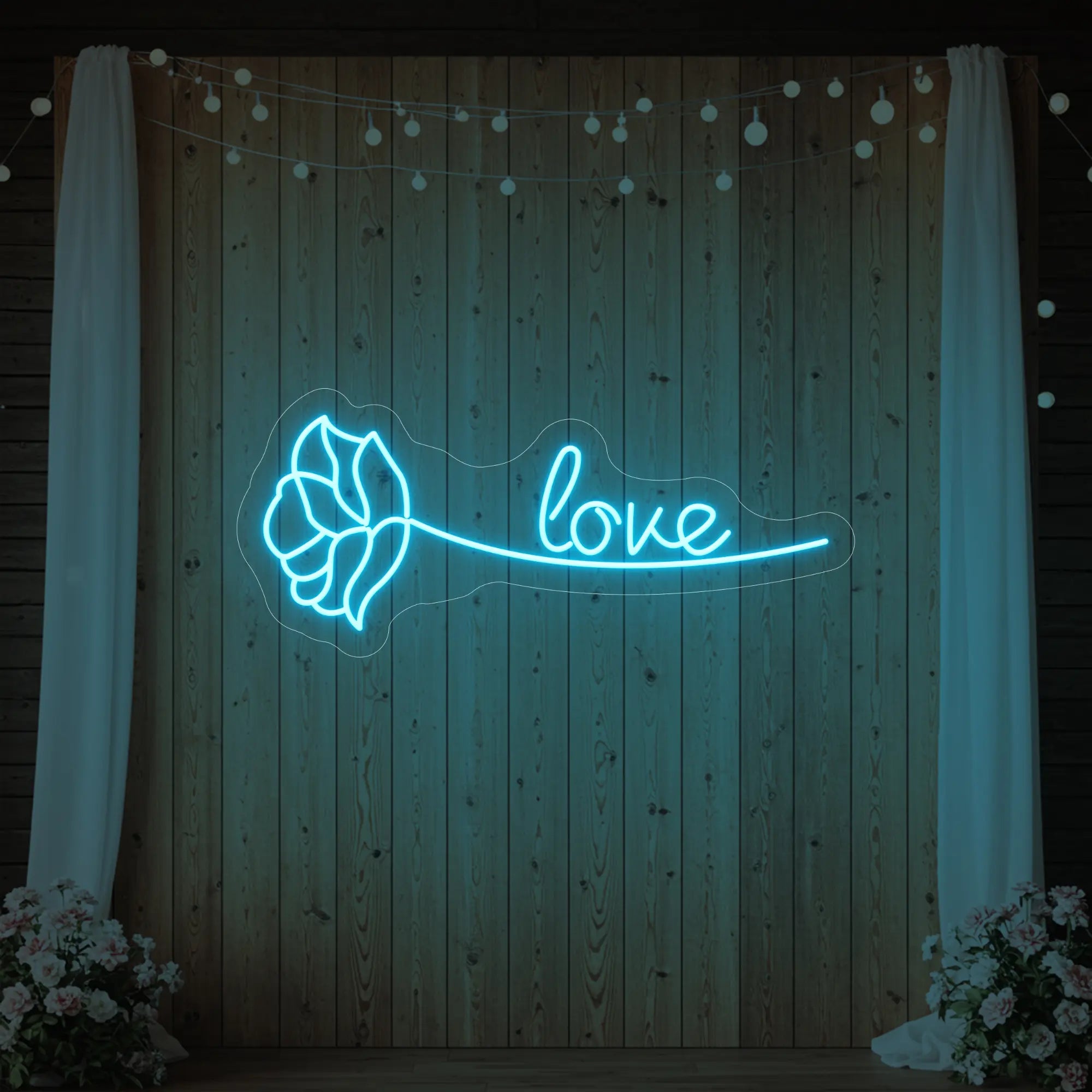 Photo of the 'Just Love Rose' neon sign glowing in ice blue against a styled interior wall.