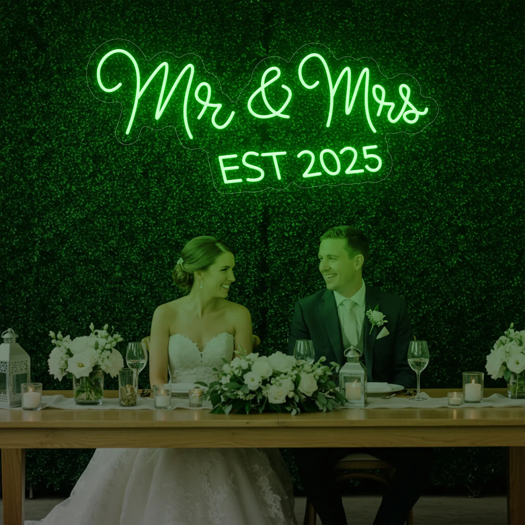 Photo of the 'Mr & Mrs EST' neon sign glowing in green against a styled interior wall.