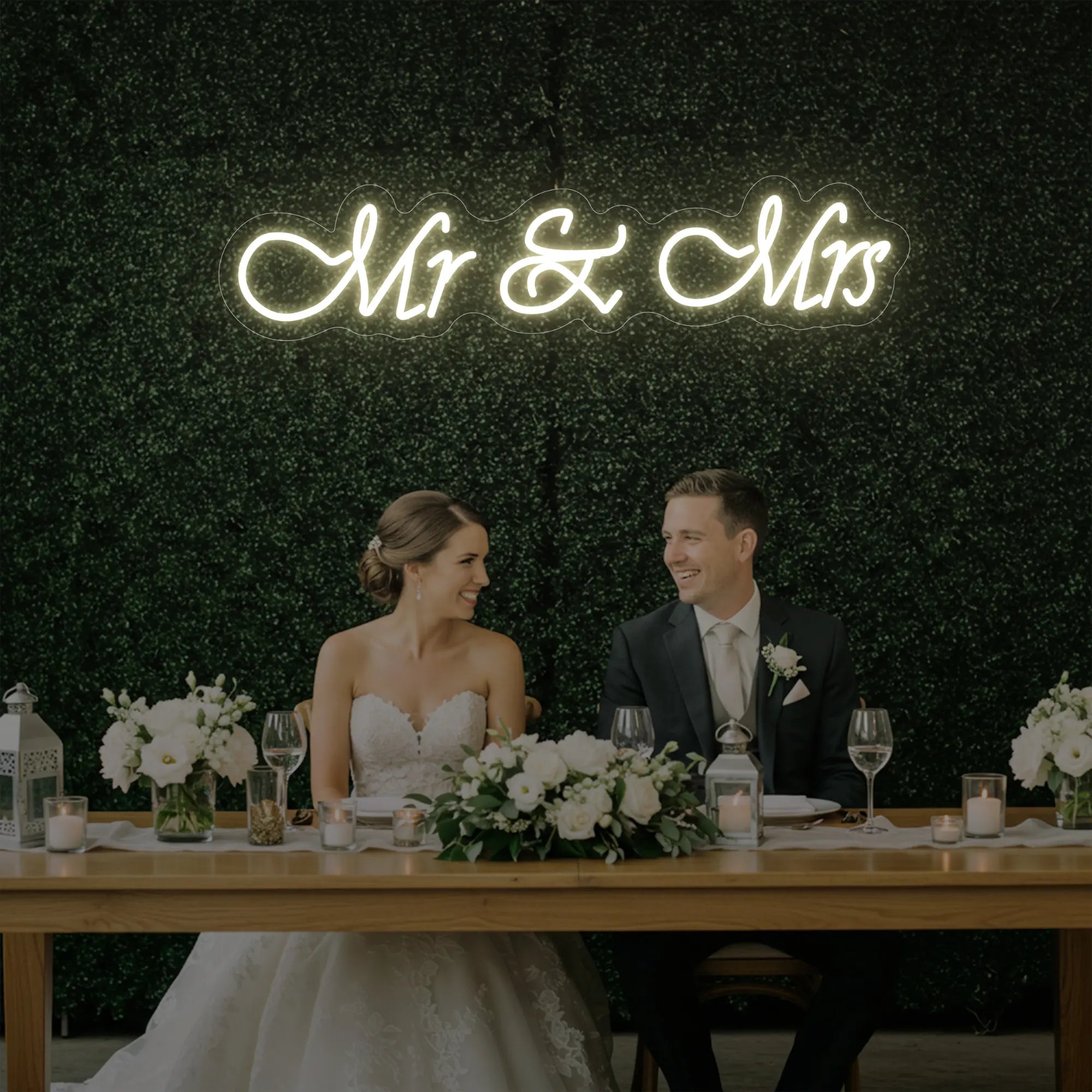 Photo of the 'Mr & Mrs' neon sign glowing in warm white against a styled interior wall.