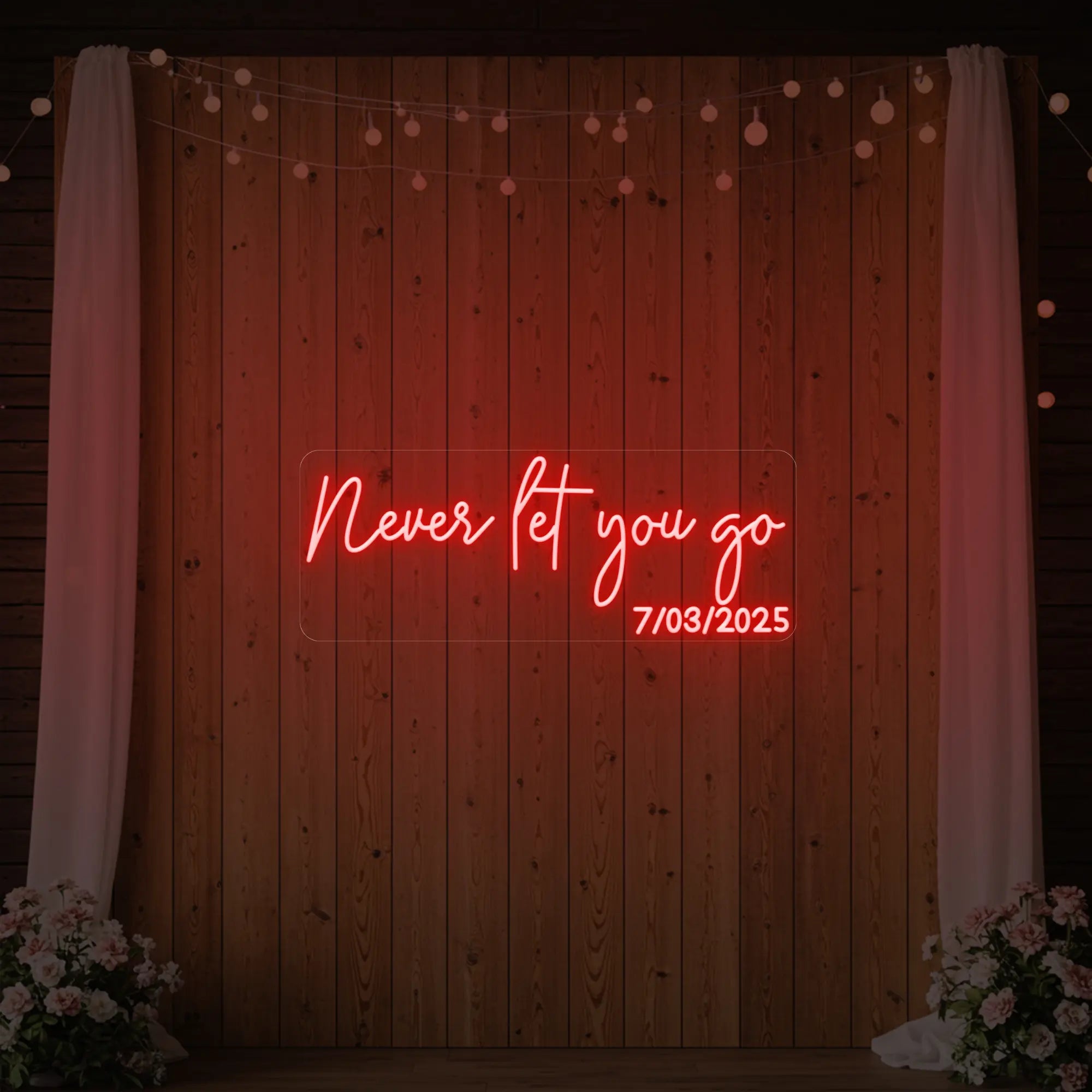 'Never Let You Go' neon sign glowing in red against a styled interior wall.