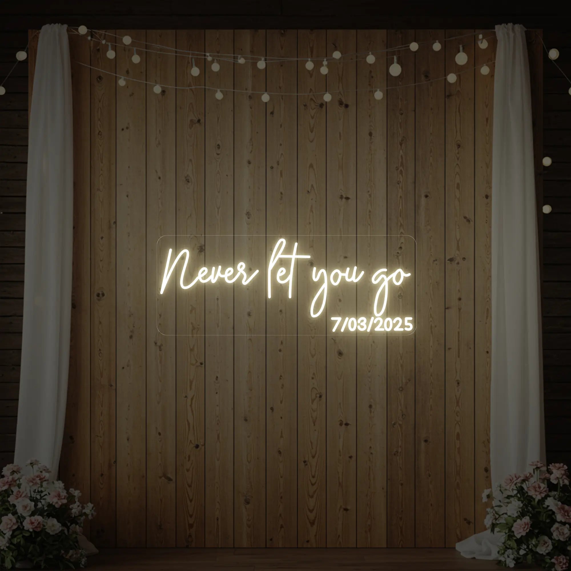 'Never Let You Go' neon sign glowing in warm white against a styled interior wall.