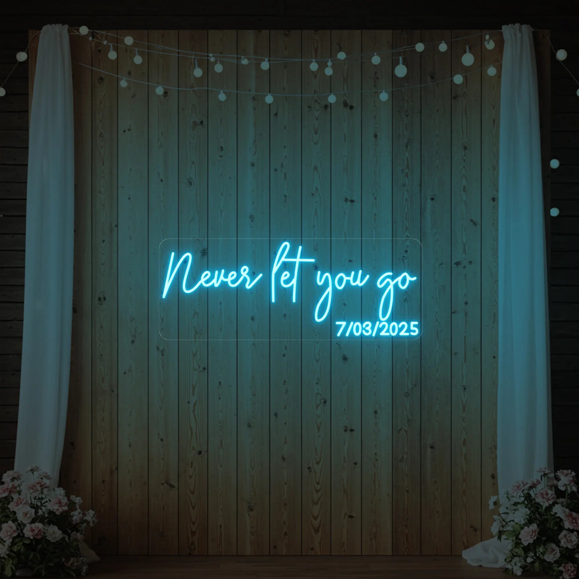 'Never Let You Go' neon sign glowing in ice blue against a styled interior wall.
