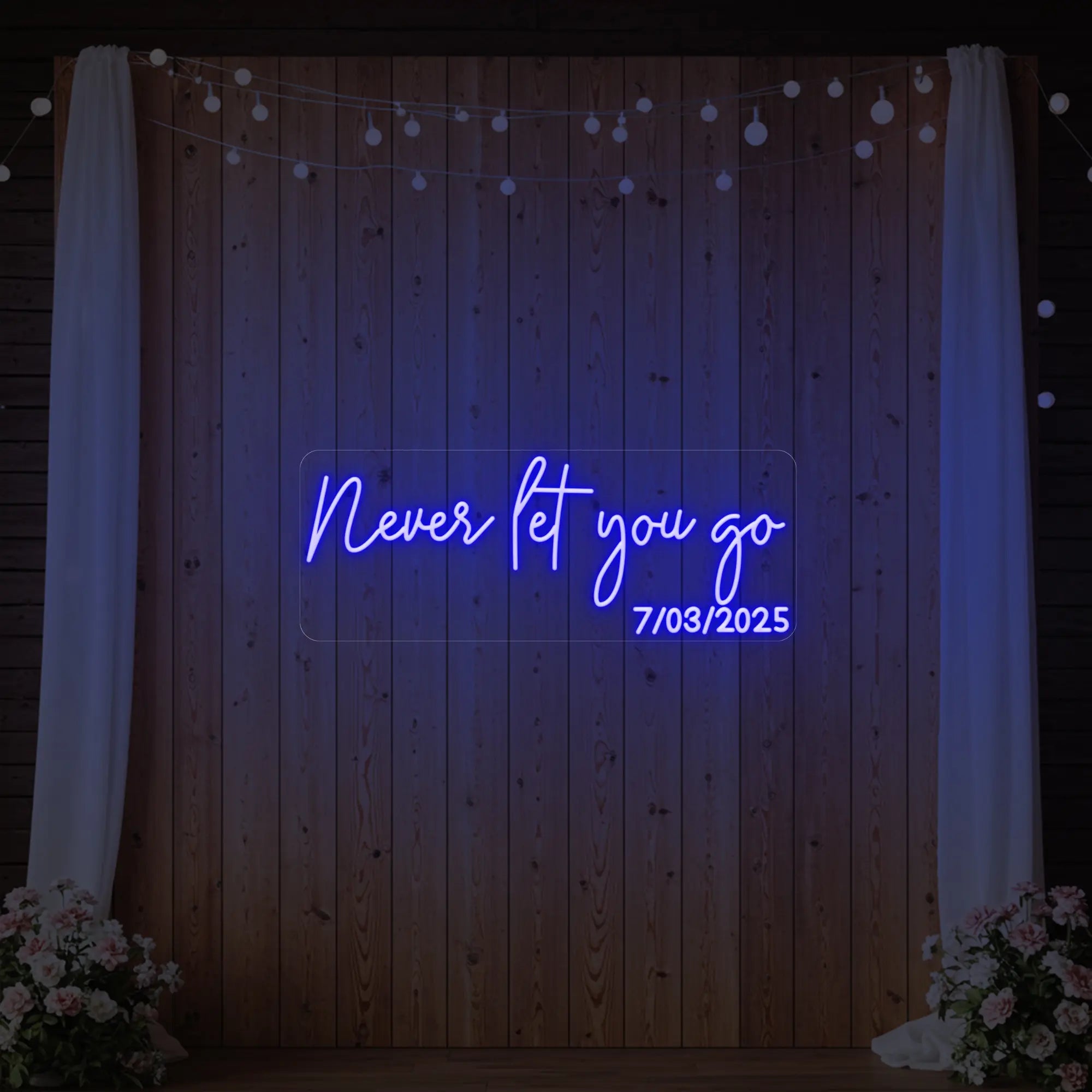 'Never Let You Go' neon sign glowing in deep blue against a styled interior wall.
