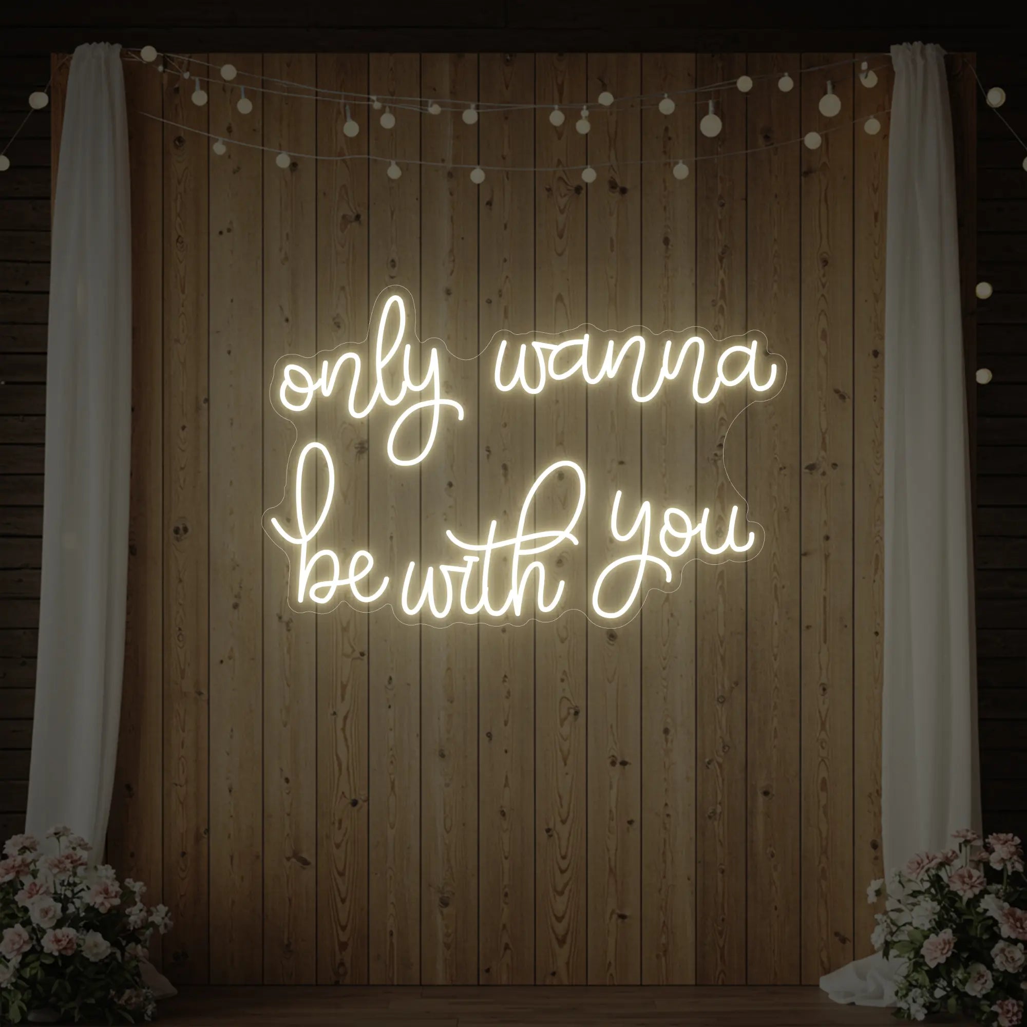 Photo of the 'Only Wanna Be With You' neon sign glowing in warm white against a styled interior wall.