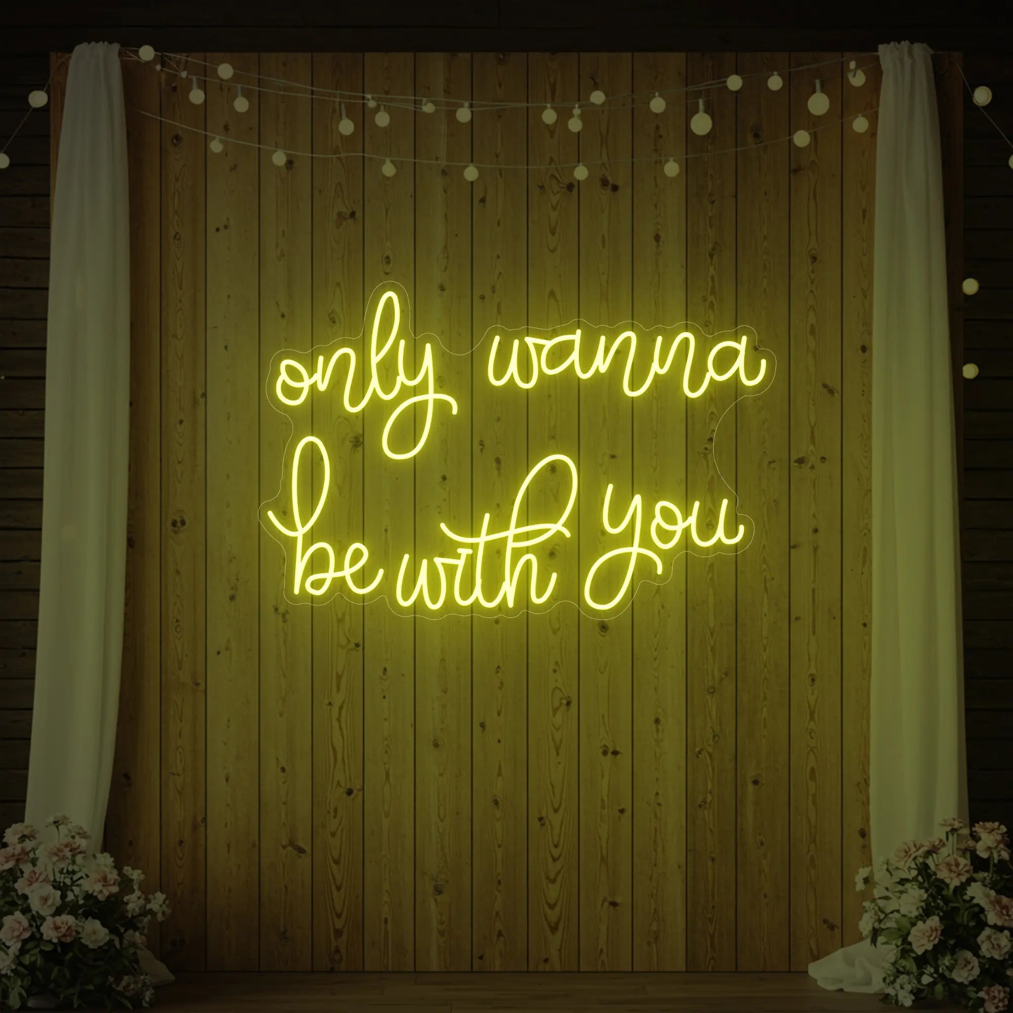 Photo of the 'Only Wanna Be With You' neon sign glowing in lemon yellow against a styled interior wall.