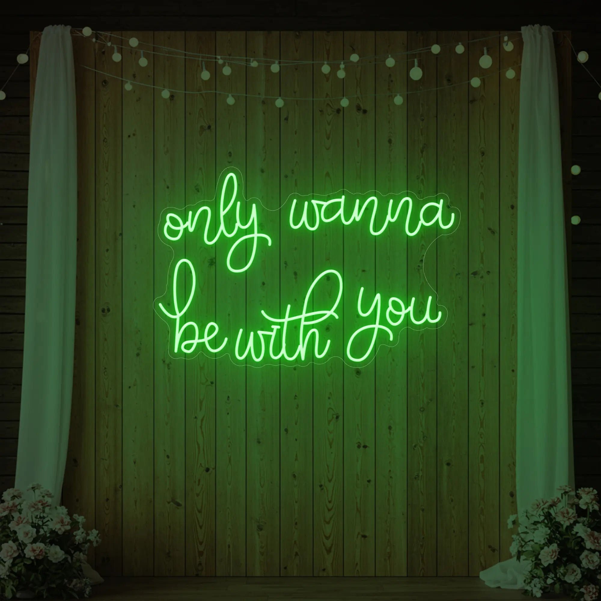 Photo of the 'Only Wanna Be With You' neon sign glowing in green against a styled interior wall.