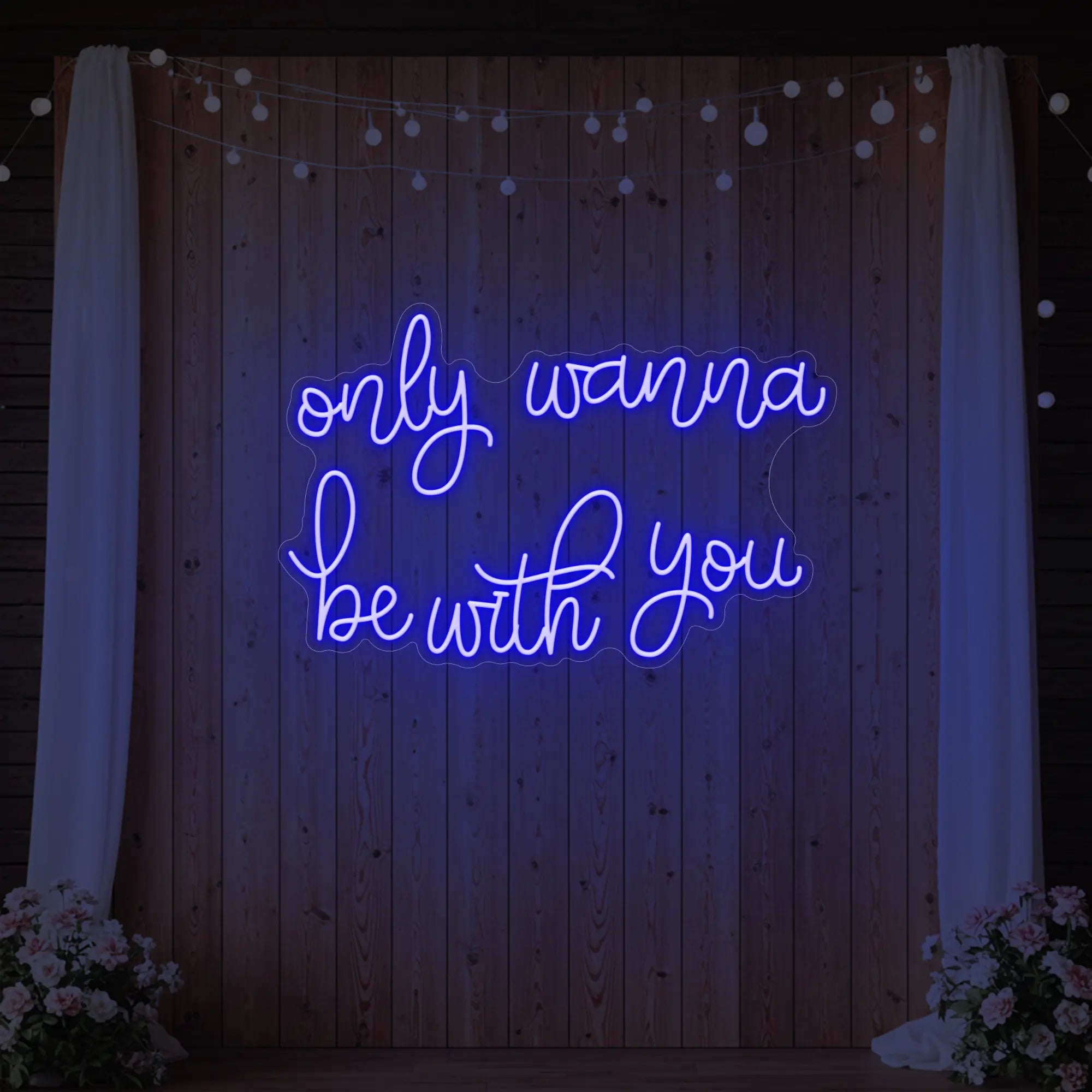 Photo of the 'Only Wanna Be With You' neon sign glowing in deep blue against a styled interior wall.