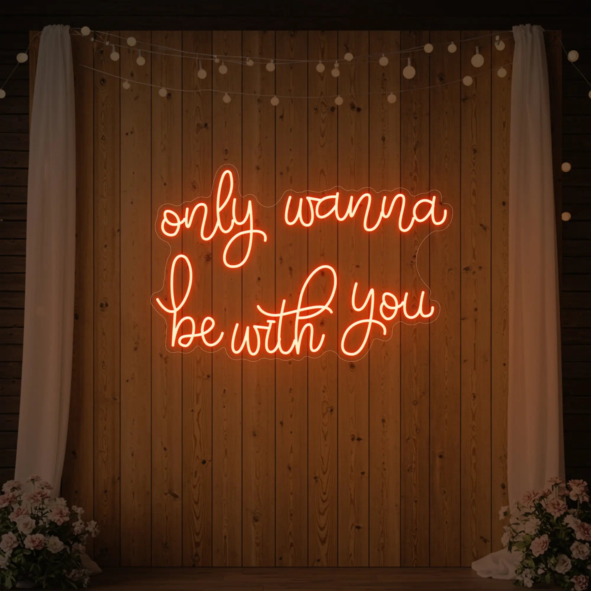 Photo of the 'Only Wanna Be With You' neon sign glowing in golden yellow against a styled interior wall.