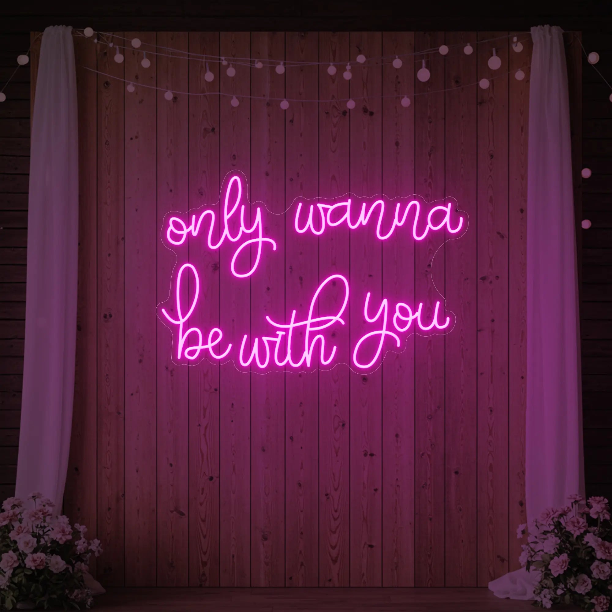 Photo of the 'Only Wanna Be With You' neon sign glowing in light pink against a styled interior wall.