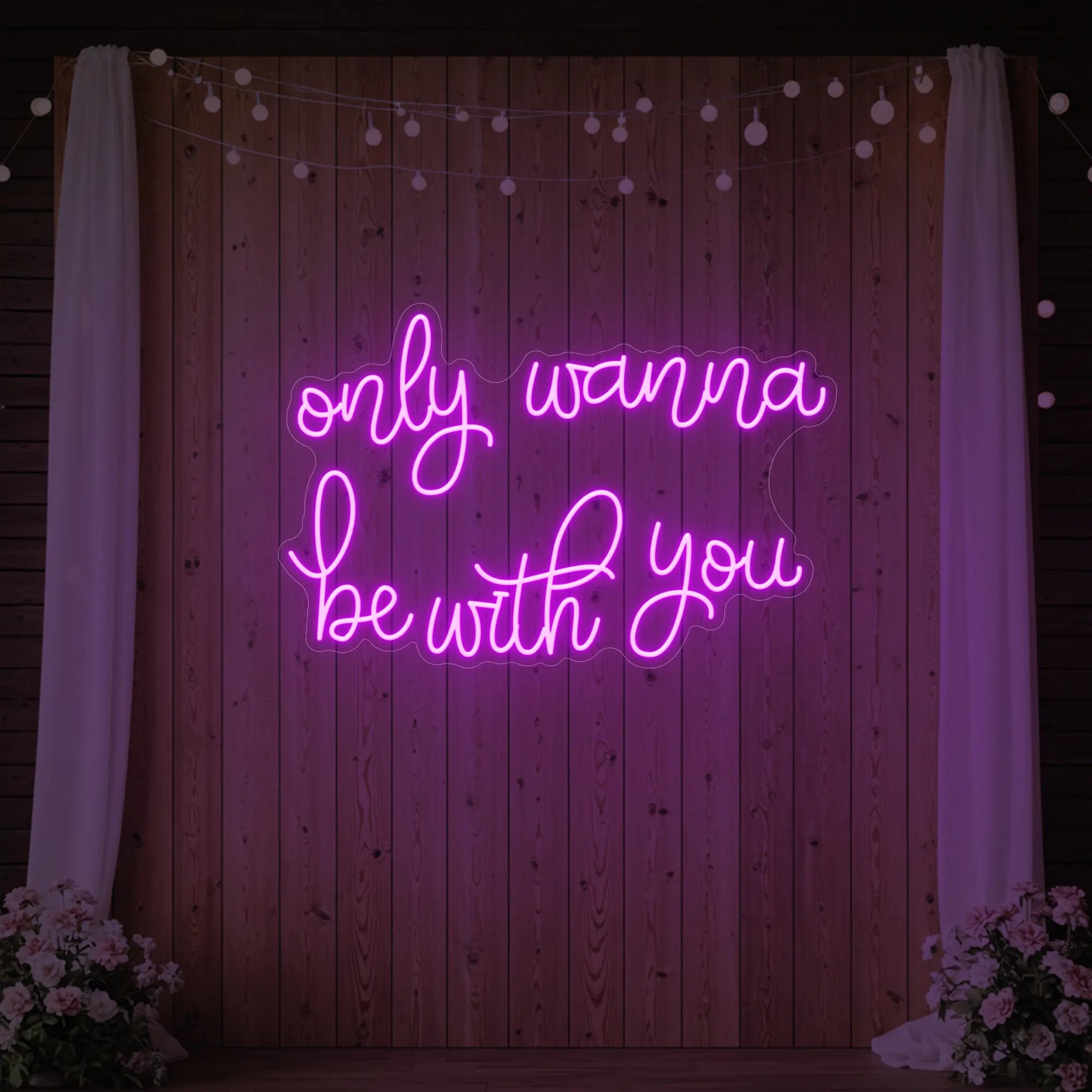 Photo of the 'Only Wanna Be With You' neon sign glowing in deep pink against a styled interior wall.