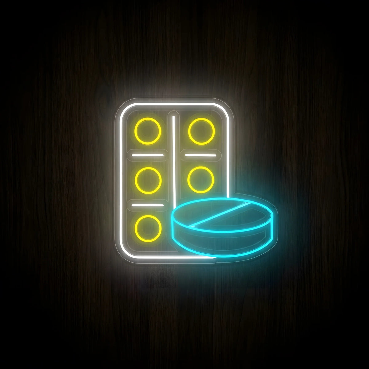 Pharmacy Tablets and Pill LED Neon Sign featuring a white blister pack with five glowing yellow tablets and a cyan round pill on clear acrylic against a dark wooden wall.