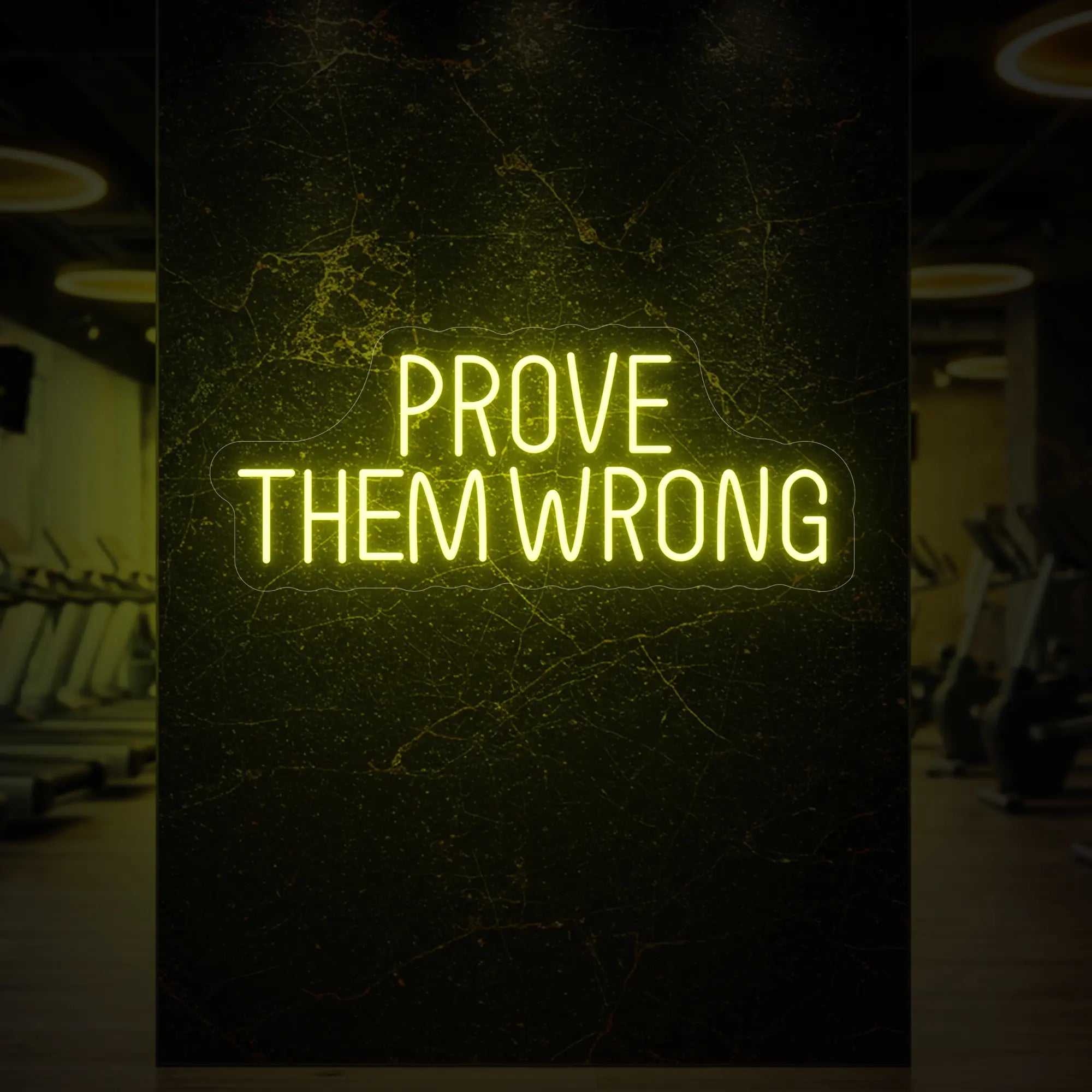 'PROVE THEM WRONG' neon sign glowing in lemon yellow against a styled interior wall.