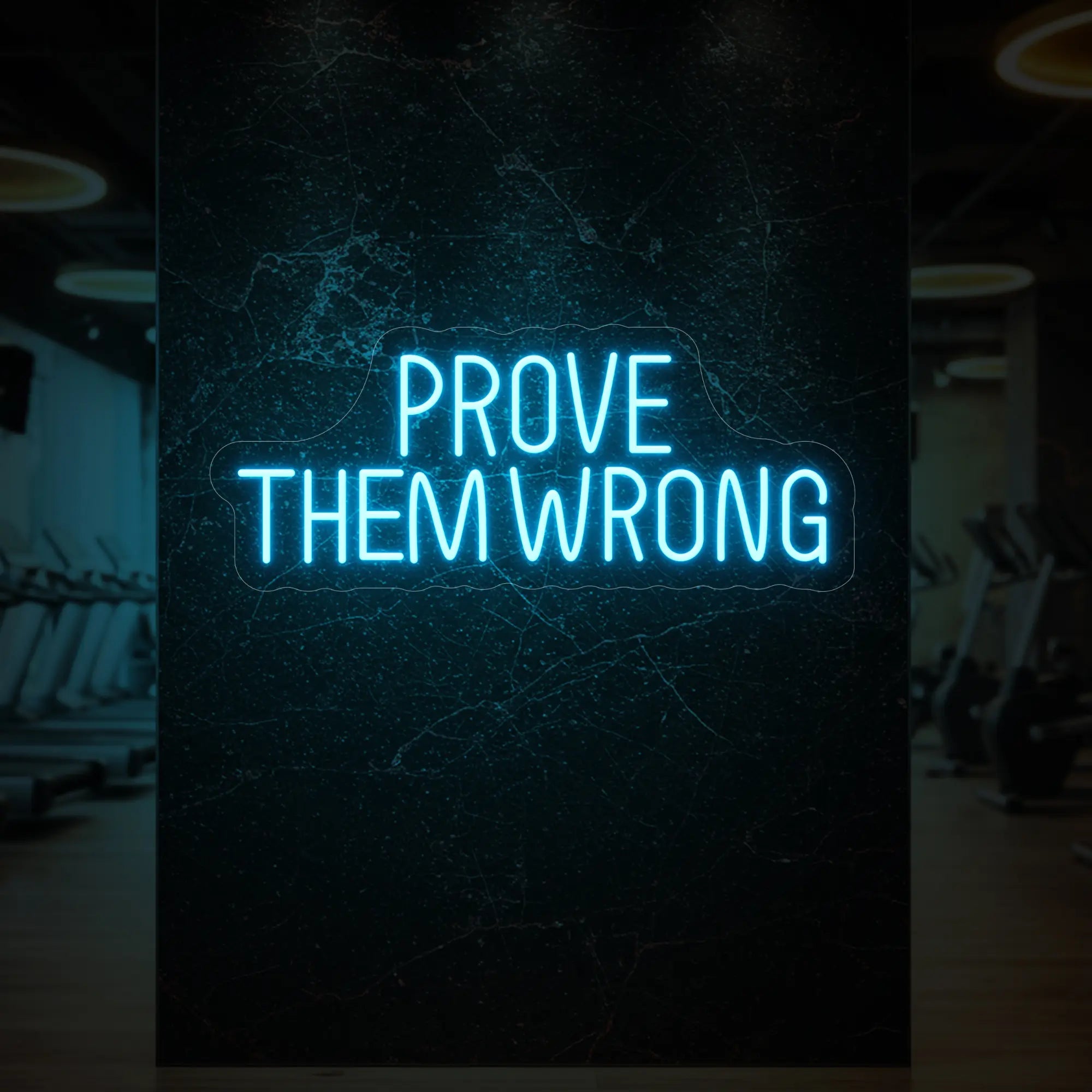 'PROVE THEM WRONG' neon sign glowing in ice blue against a styled interior wall.
