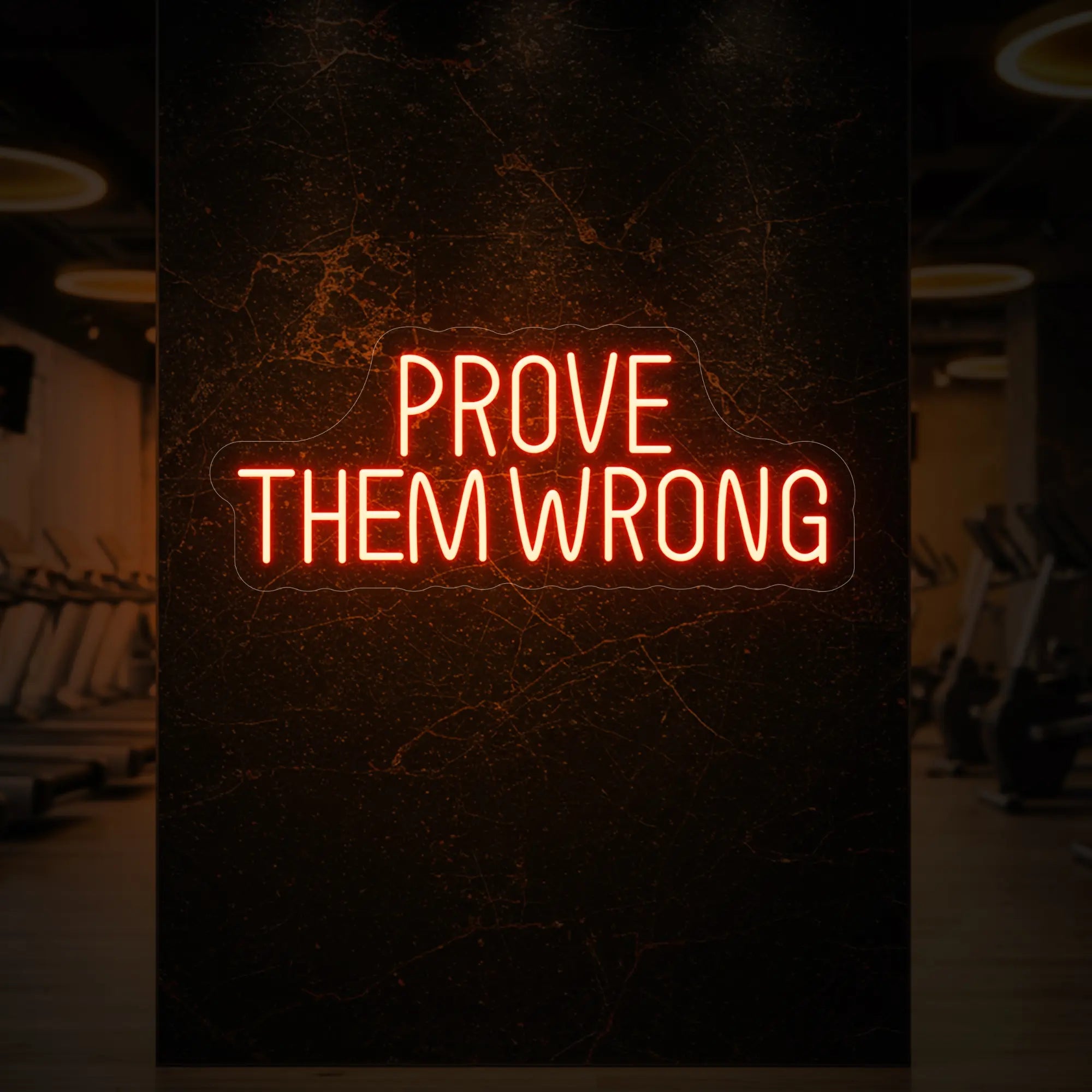 'PROVE THEM WRONG' neon sign glowing in golden yellow against a styled interior wall.