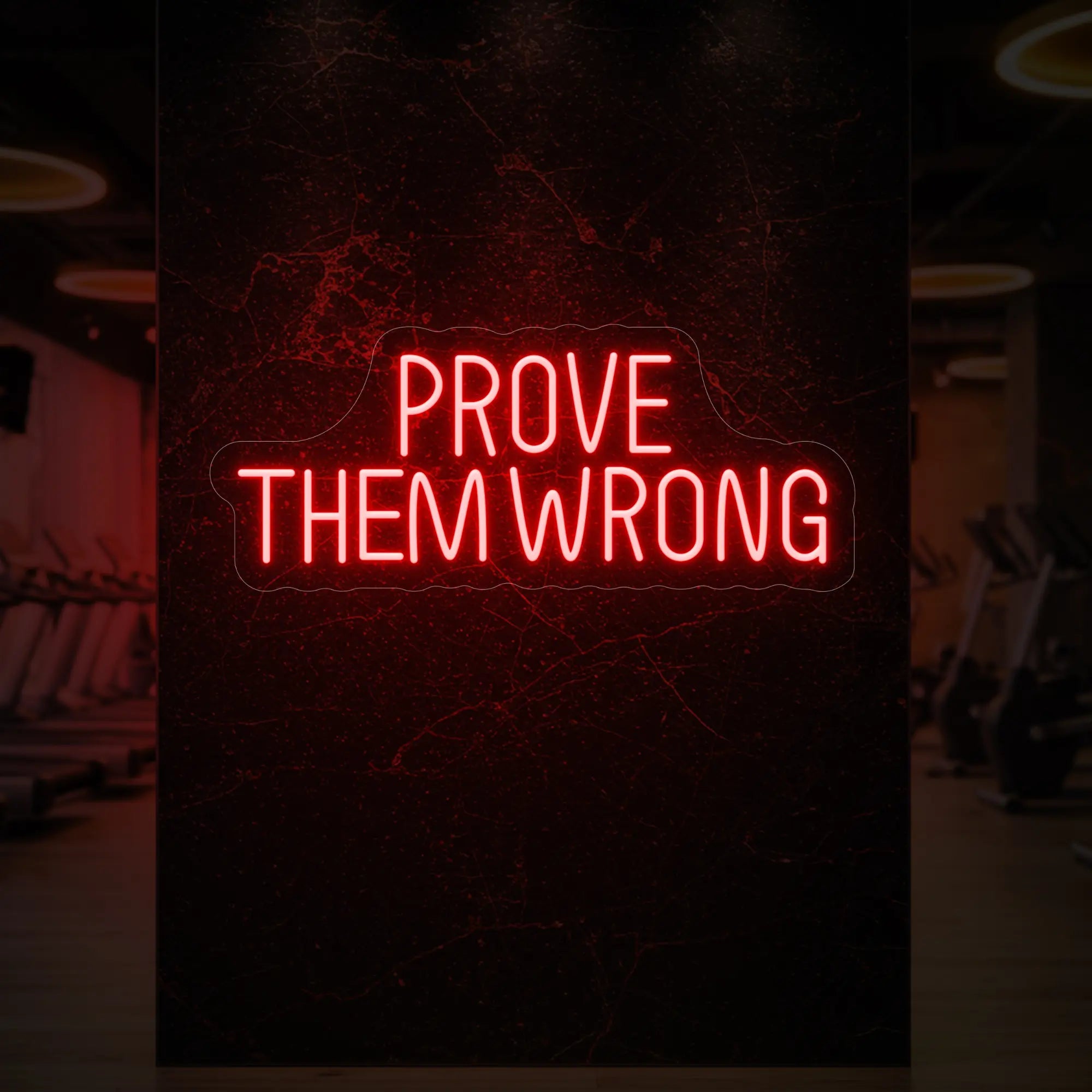 'PROVE THEM WRONG' neon sign glowing in red against a styled interior wall.