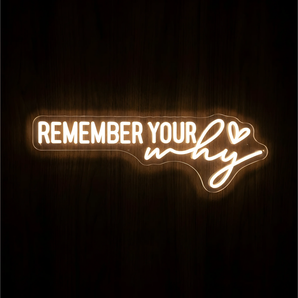 “REMEMBER YOUR why” LED Neon Sign glowing in warm white, with uppercase lettering, the word “why” in script, and a small outlined heart on clear acrylic against a dark wood background, suited to home offices and workspaces.
