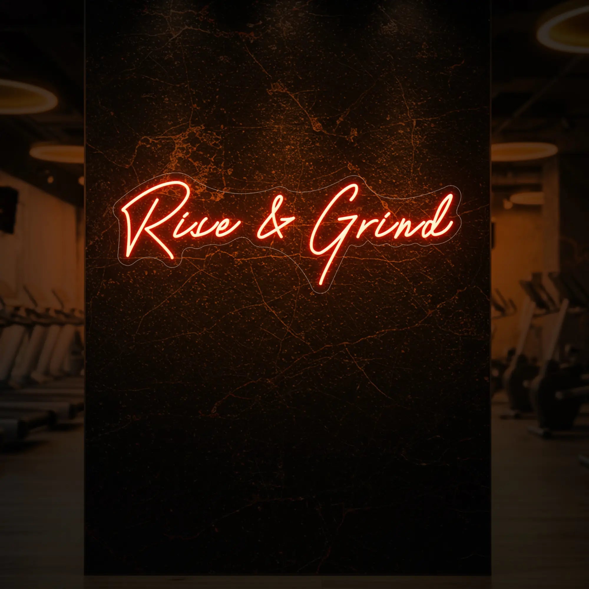 'Rise & Grind' neon sign glowing in golden yellow against a styled interior wall.
