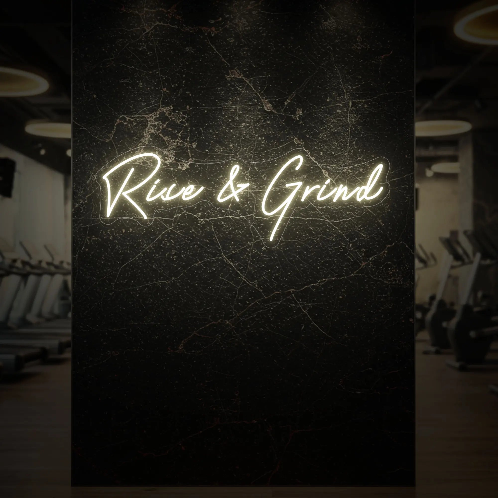 'Rise & Grind' neon sign glowing in warm white against a styled interior wall.