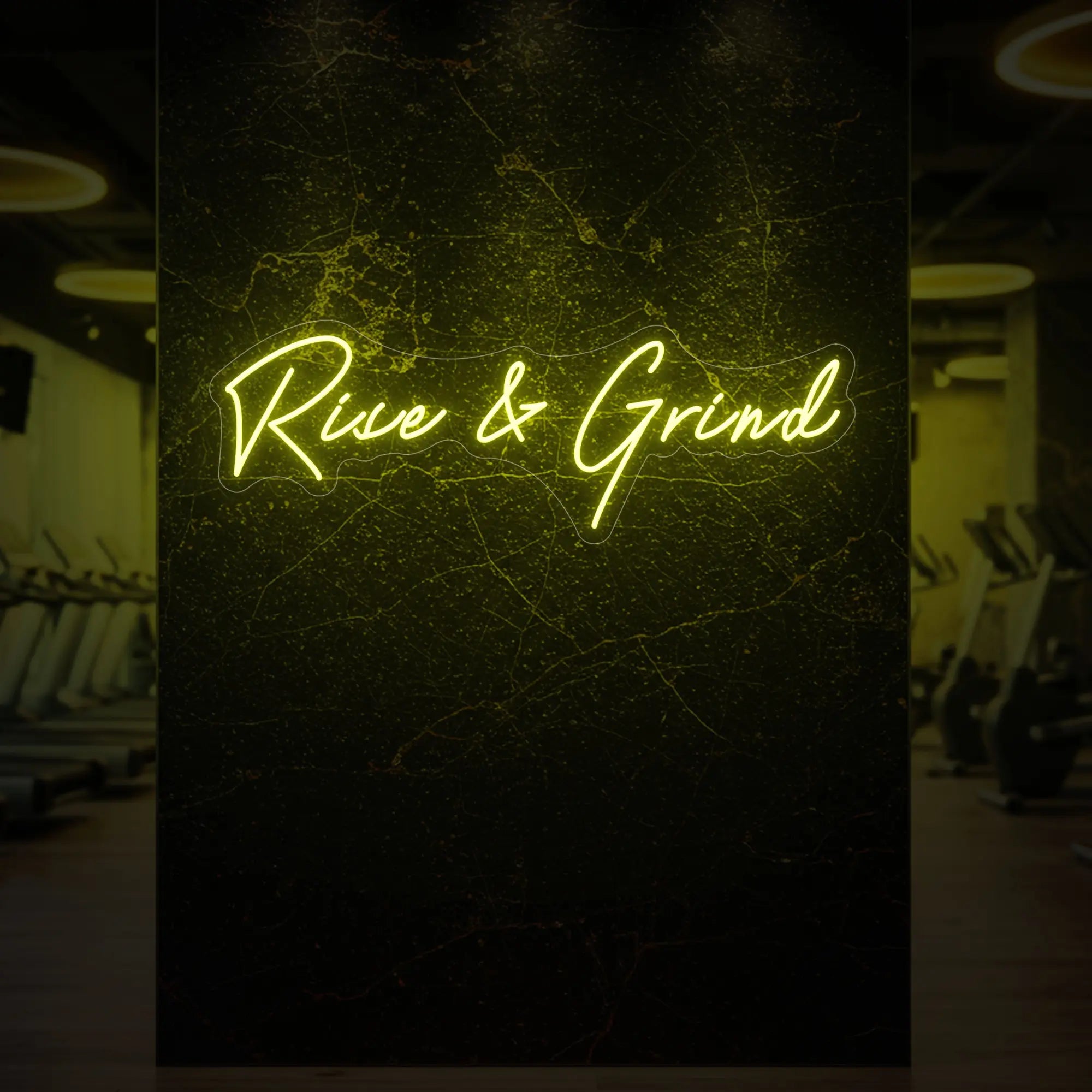 'Rise & Grind' neon sign glowing in lemon yellow against a styled interior wall.