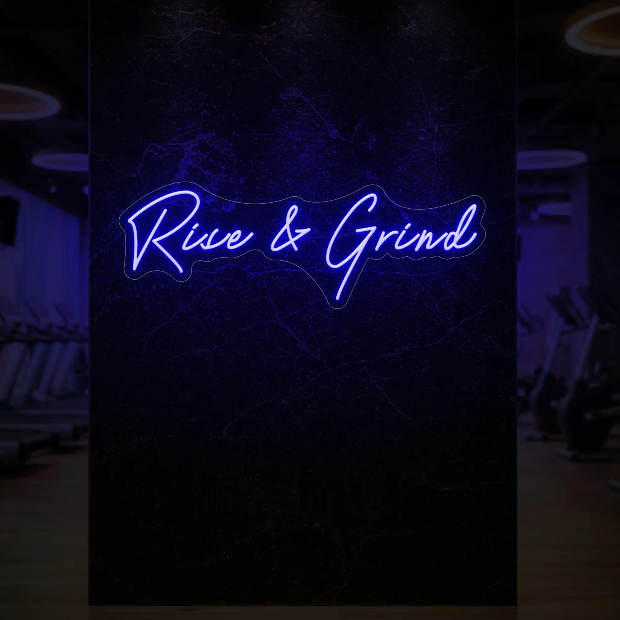 'Rise & Grind' neon sign glowing in deep blue against a styled interior wall.