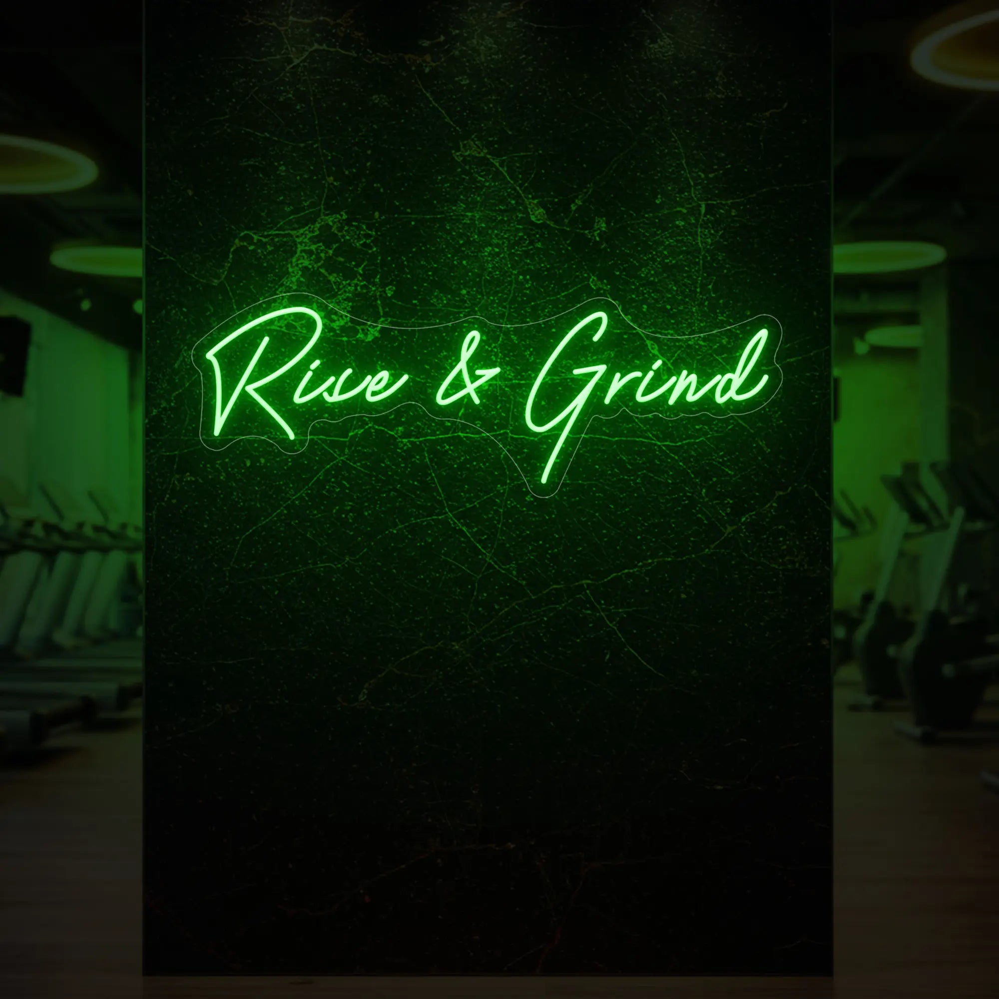 'Rise & Grind' neon sign glowing in green against a styled interior wall.