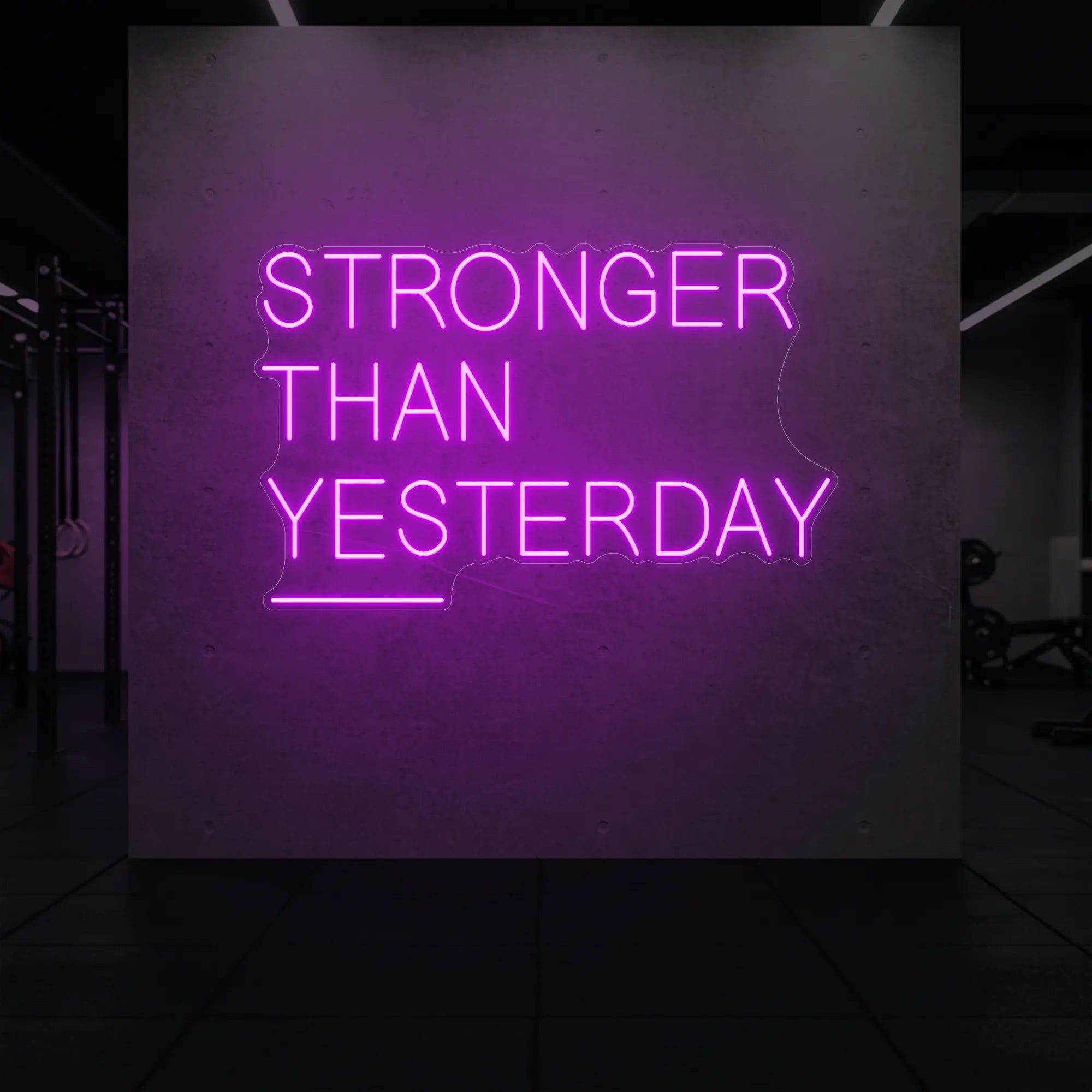 'Stronger Than Yesterday' neon sign glowing in deep pink against a styled interior wall.