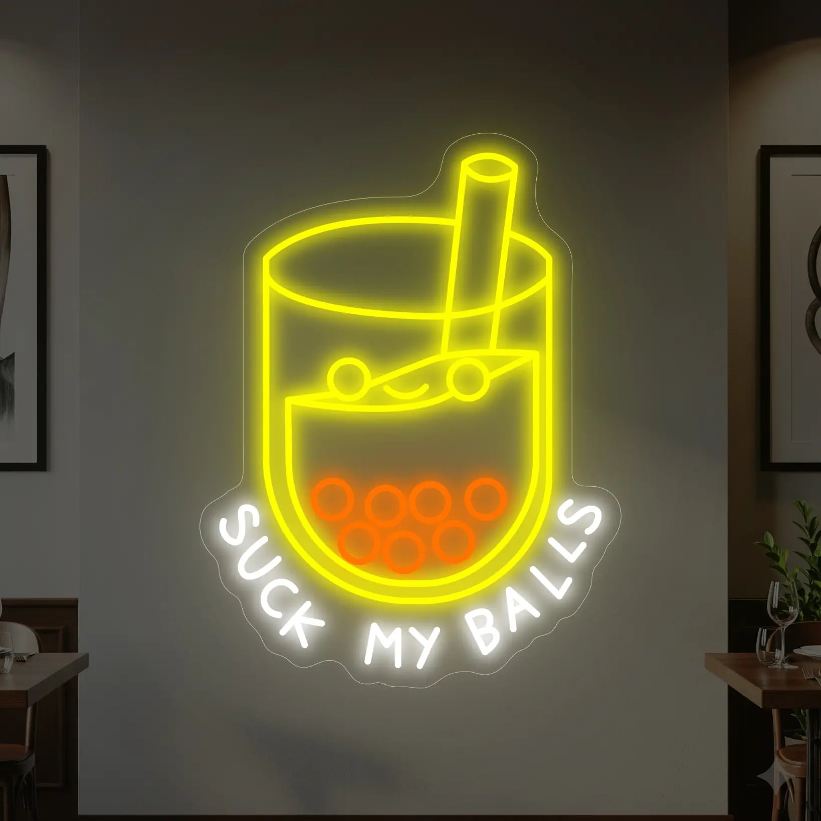 Photo of the 'SUCK MY BALLS' neon sign glowing in multi-color against a styled interior wall.