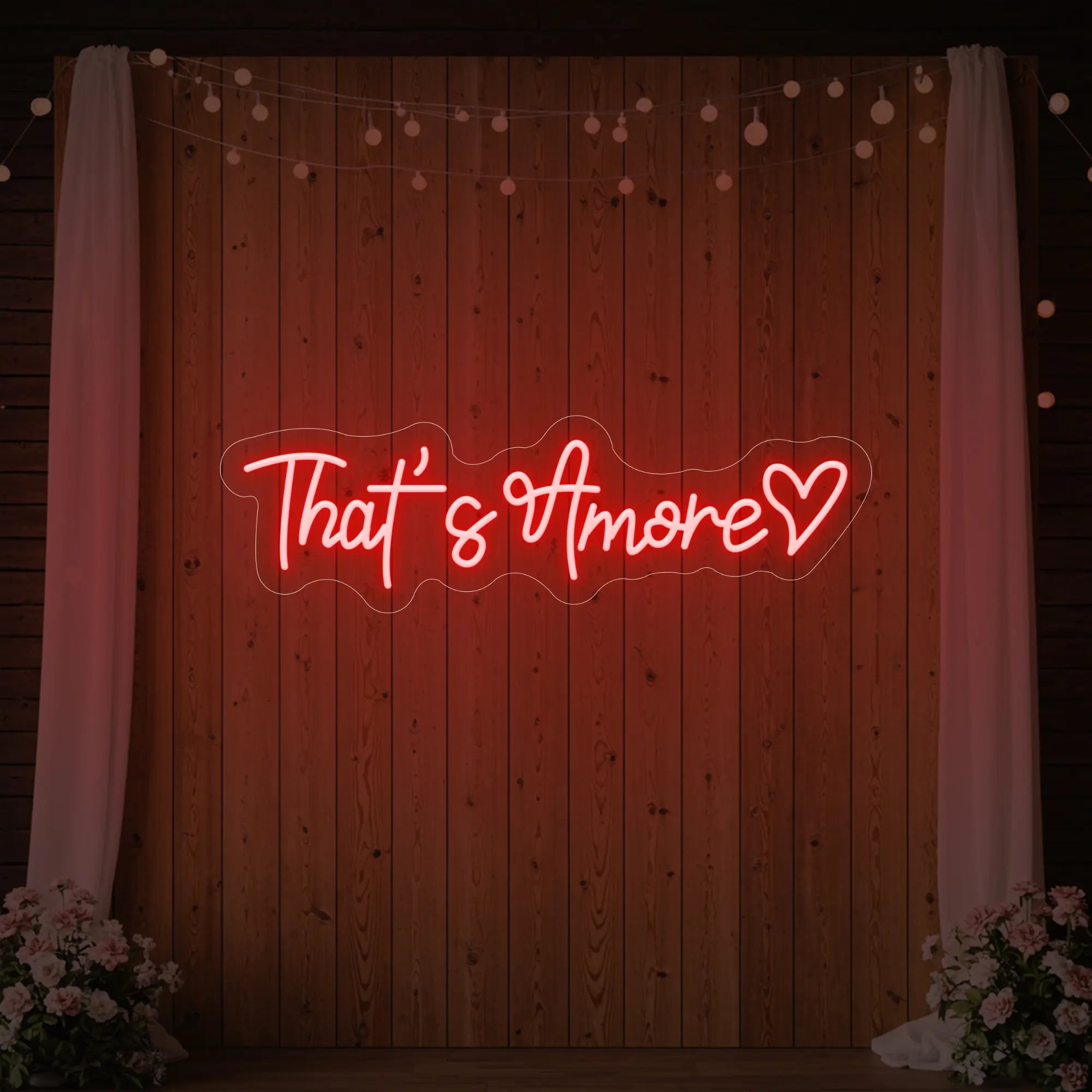 Photo of the 'That's Amore with Heart' neon sign glowing in red against a styled interior wall.