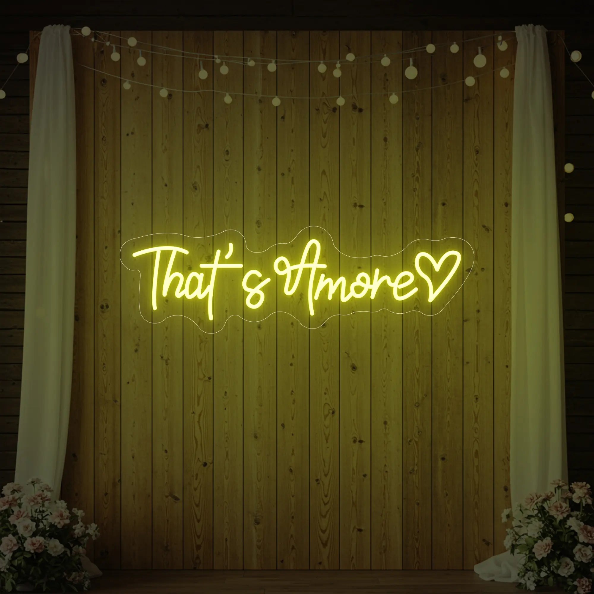 Photo of the 'That's Amore with Heart' neon sign glowing in lemon yellow against a styled interior wall.