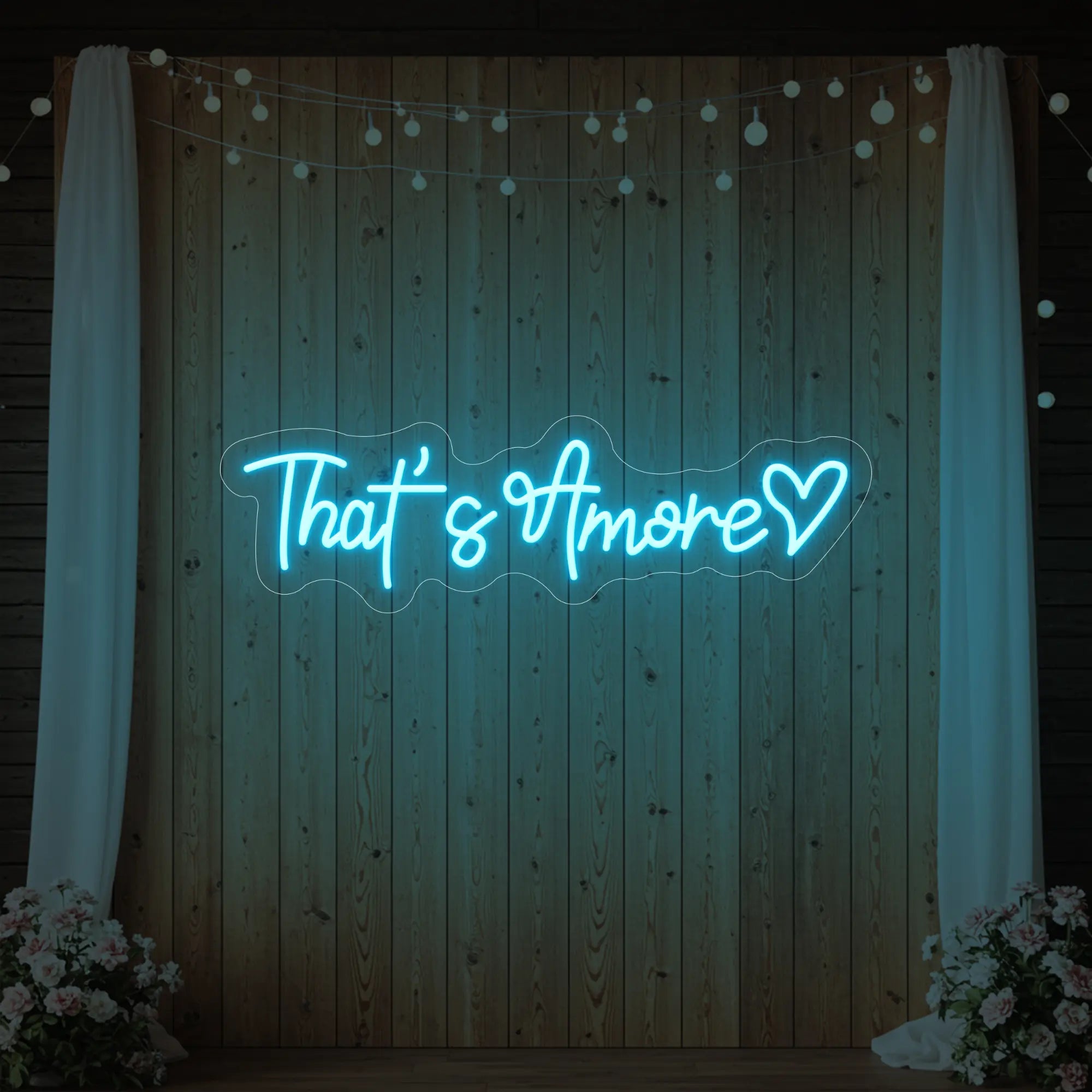 Photo of the 'That's Amore with Heart' neon sign glowing in ice blue against a styled interior wall.