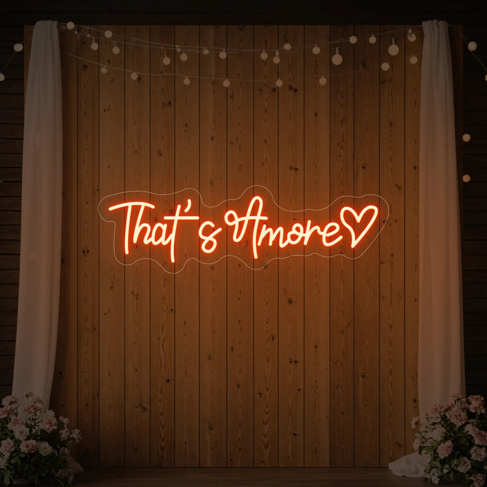 Photo of the 'That's Amore with Heart' neon sign glowing in golden yellow against a styled interior wall.