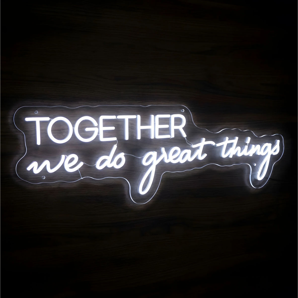 Together We Do Great Things LED Neon Sign in bright white block and script lettering on clear acrylic against a dark wood background, ideal for team offices and collaborative workspaces.