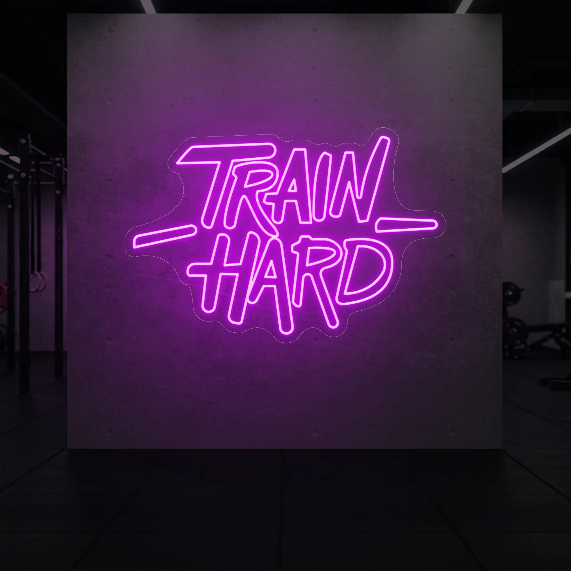 'TRAIN HARD' neon sign glowing in dep pink against a styled interior wall.
