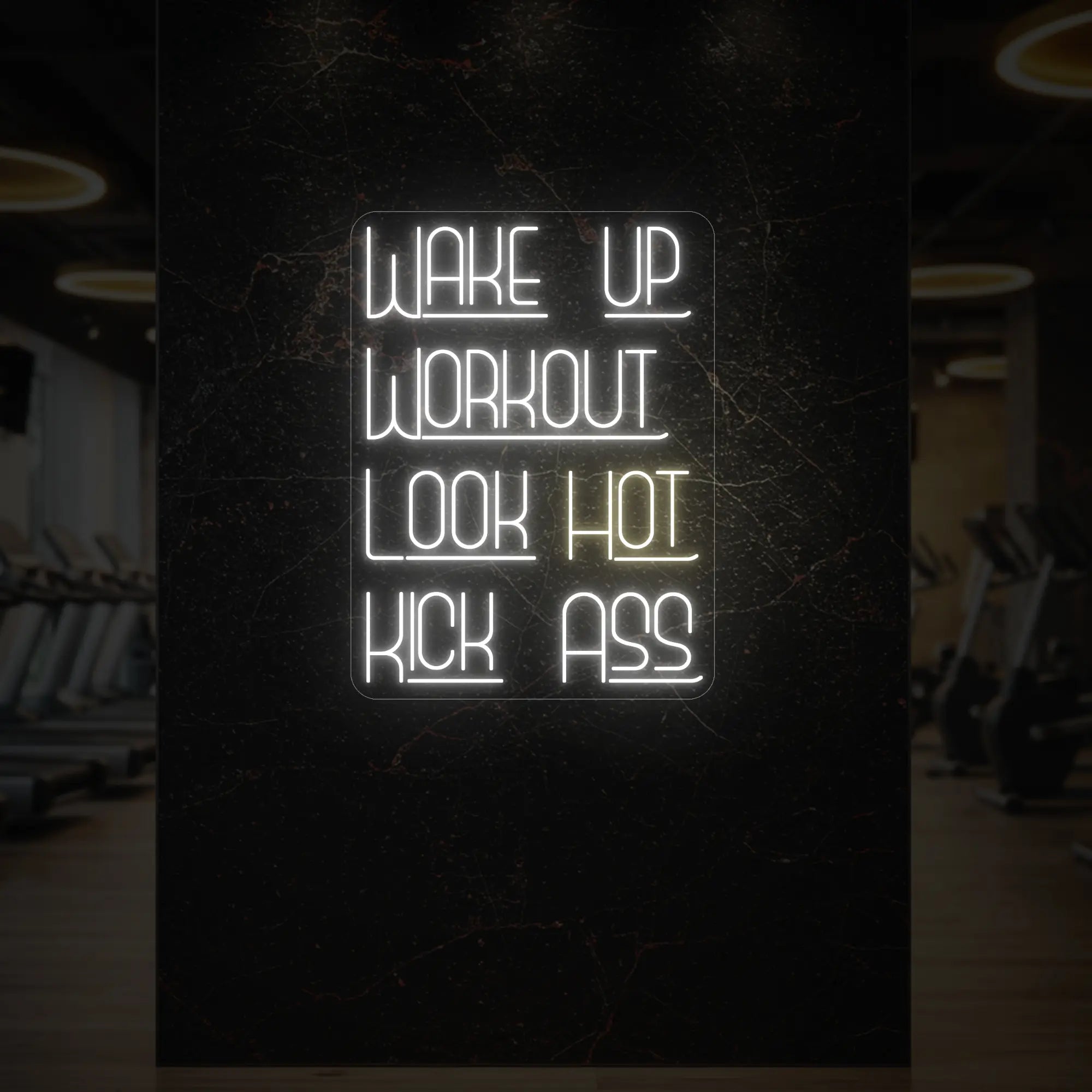 'WAKE UP WORKOUT LOOK HOT KICK ASS' neon sign glowing in warm white against a styled interior wall.