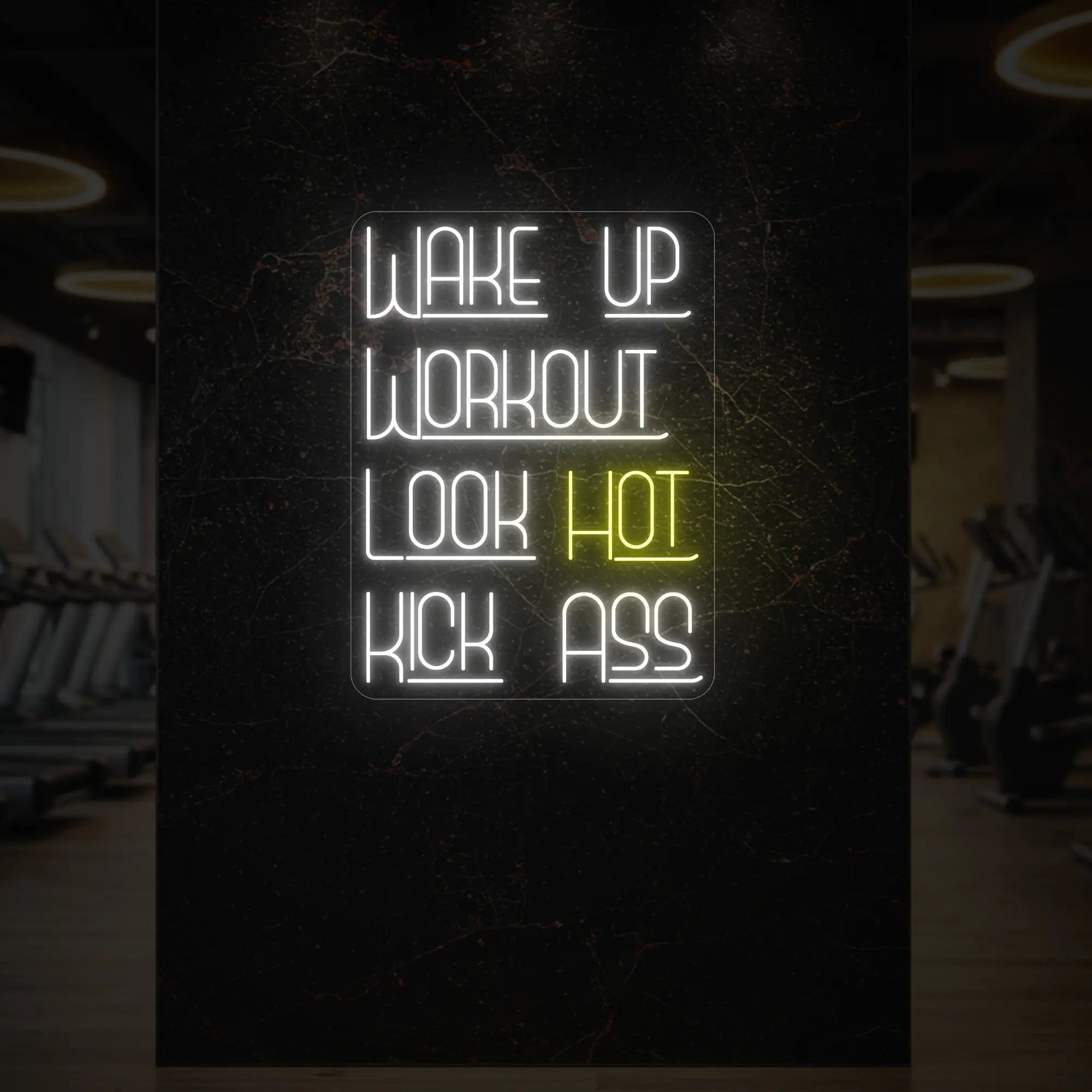 'WAKE UP WORKOUT LOOK HOT KICK ASS' neon sign glowing in lemon yellow against a styled interior wall.