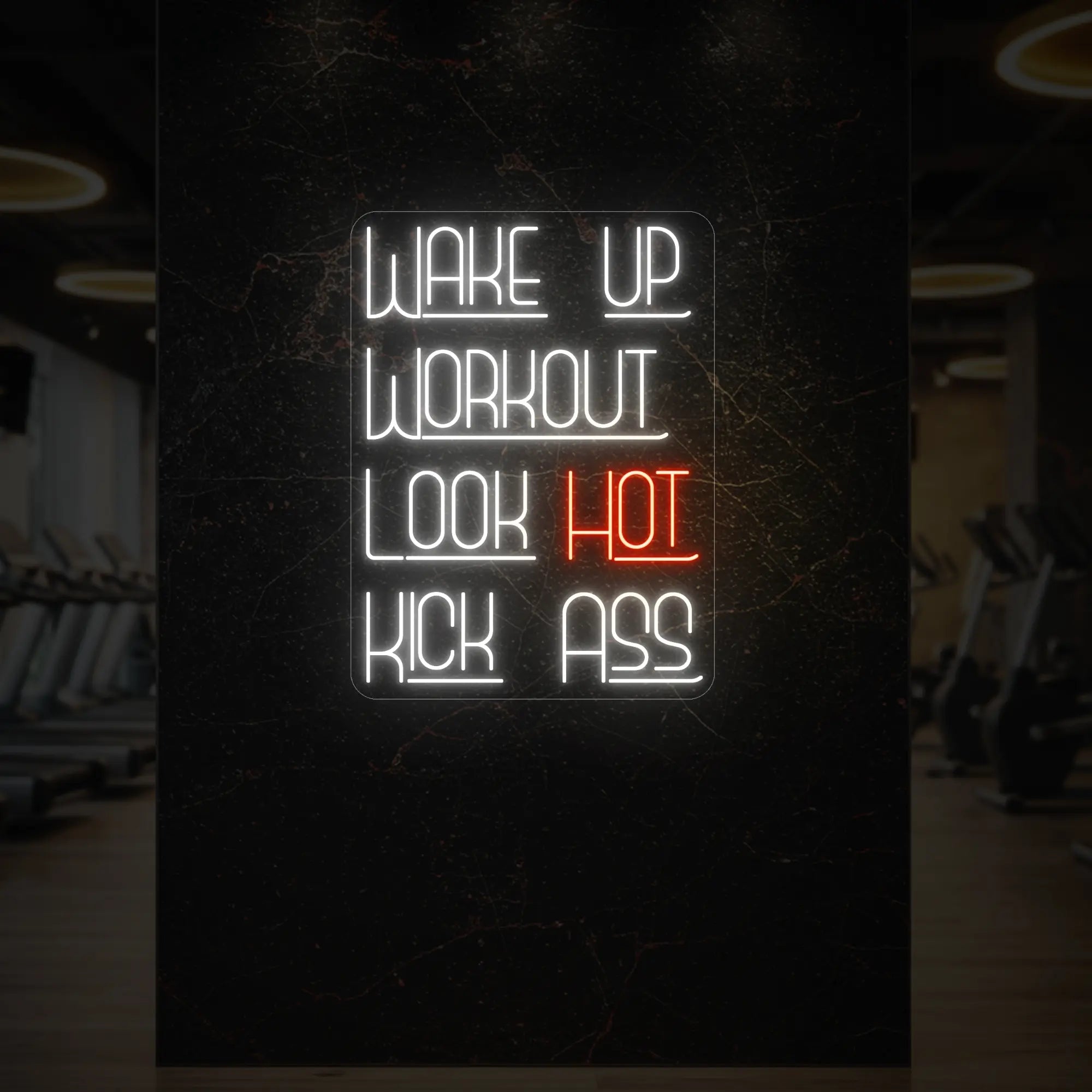 'WAKE UP WORKOUT LOOK HOT KICK ASS' neon sign glowing in golden yellow against a styled interior wall.