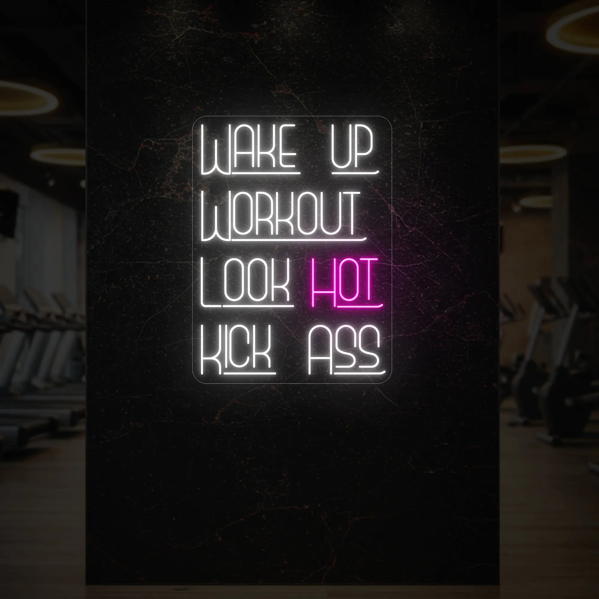 'WAKE UP WORKOUT LOOK HOT KICK ASS' neon sign glowing in light pink against a styled interior wall.