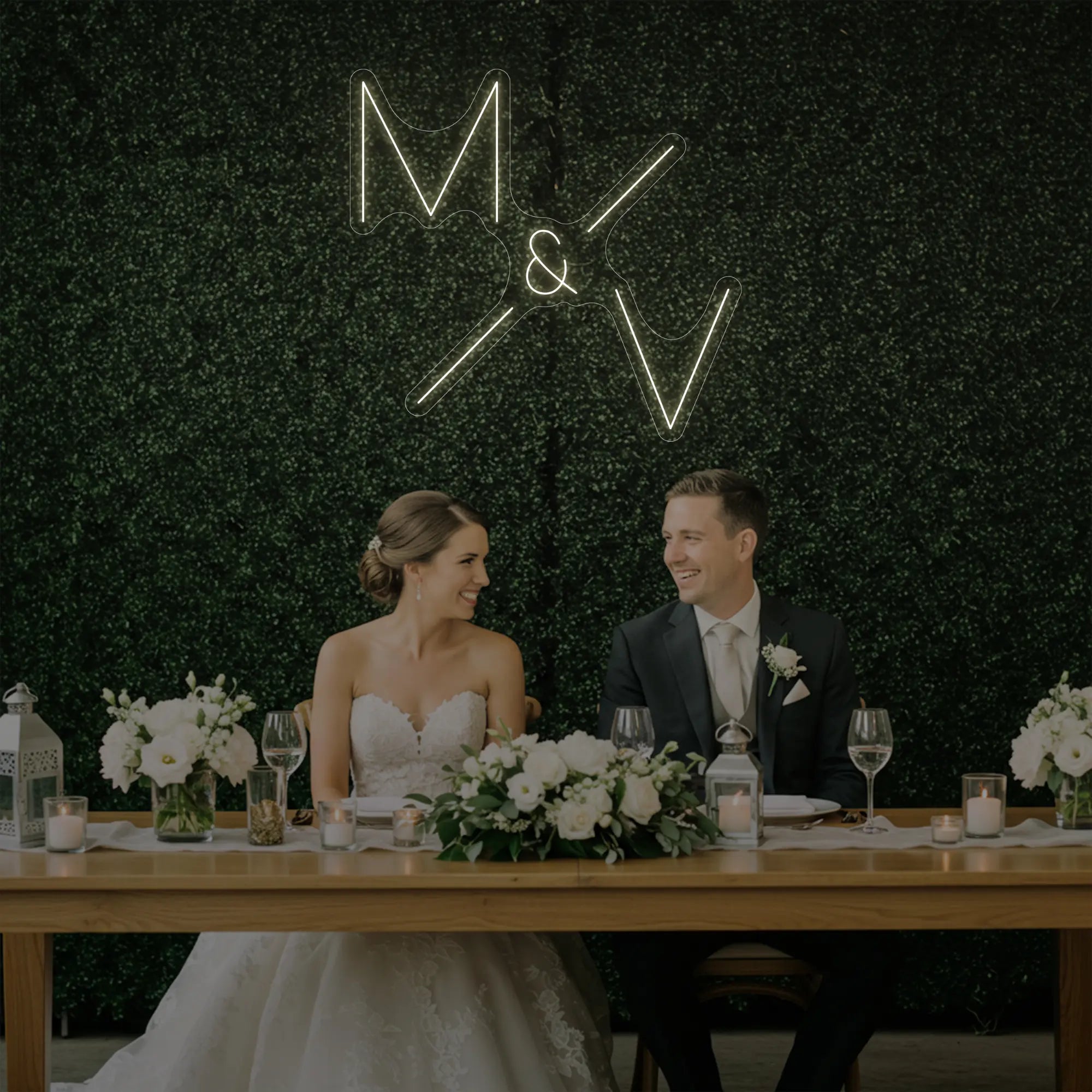 Photo of the 'Wedding Initials Custom Neon Sign V1' neon sign glowing in warm white against a styled interior wall.